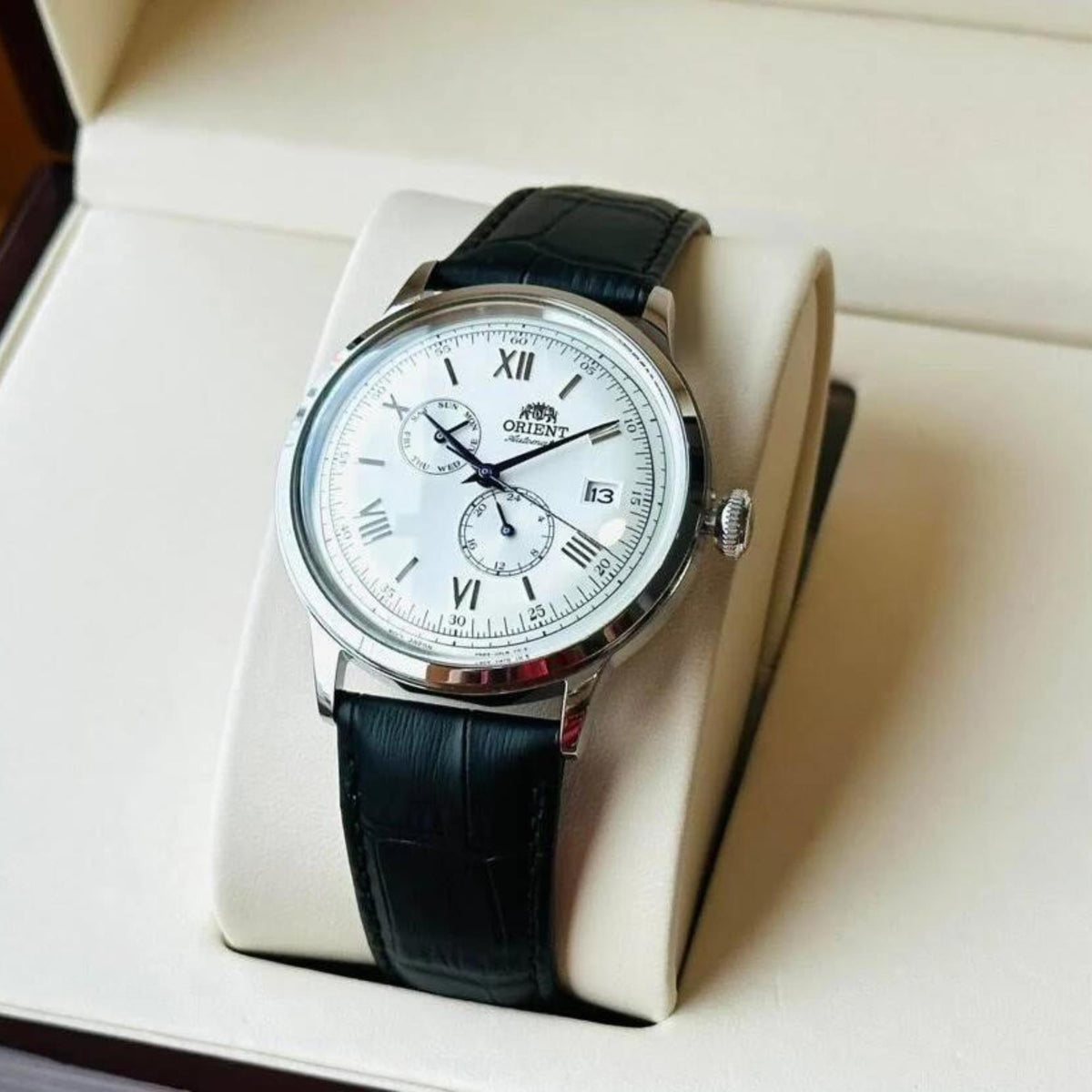 Mens automatic wristwatch with silver case, white dial, black leather strap and subdials