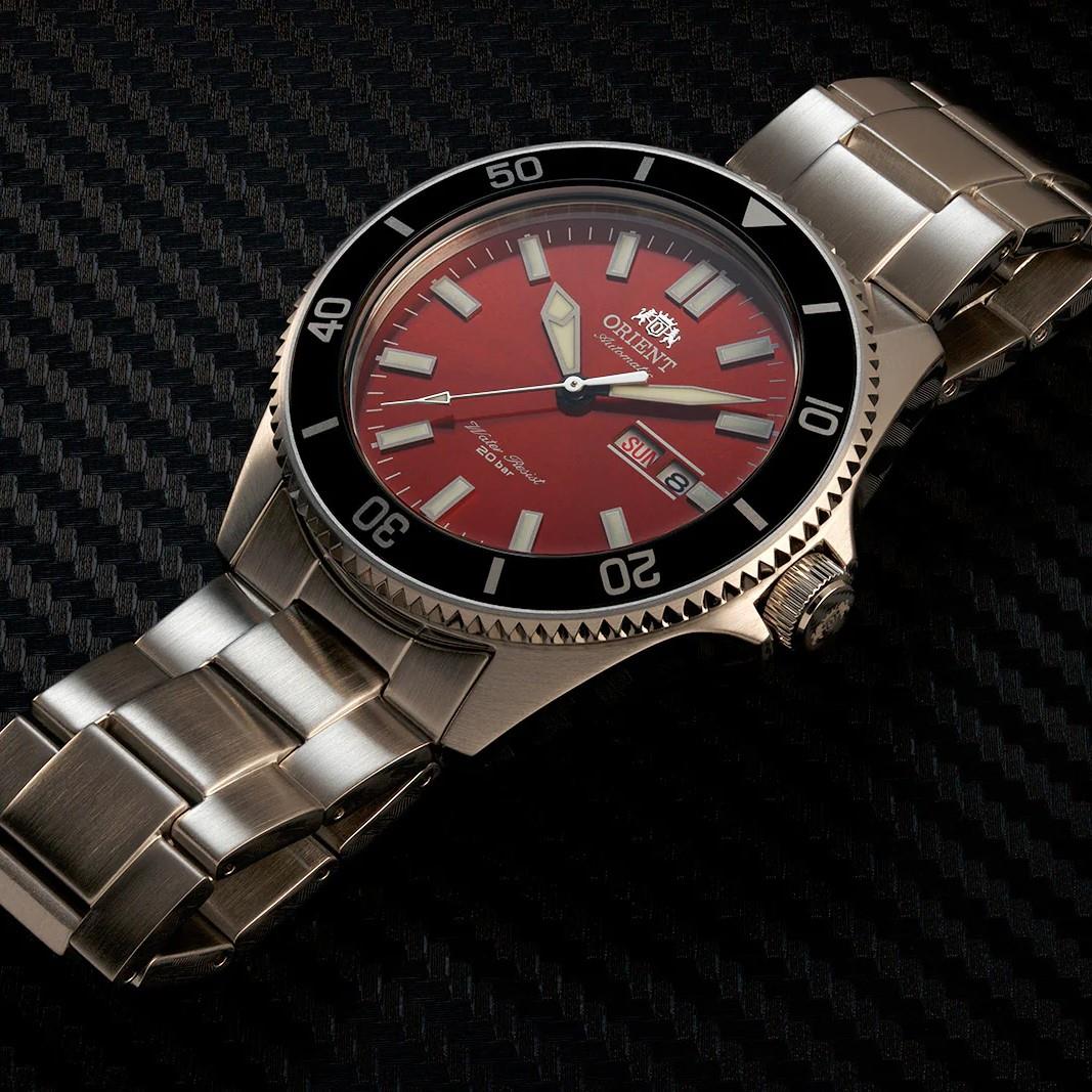 Red dial automatic men’s watch with stainless steel bracelet and black diver-style bezel