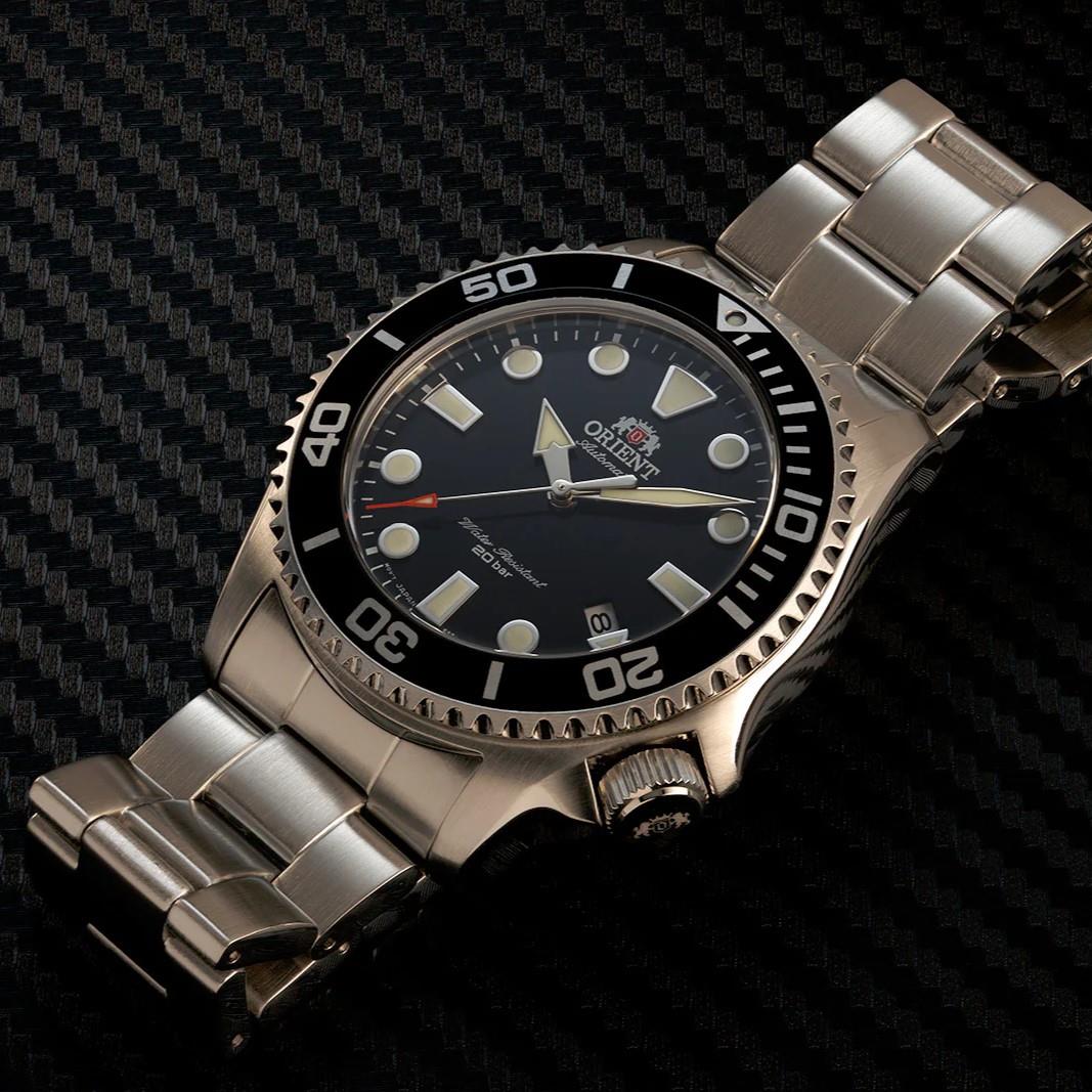 Steel diver-style watch with black dial, round bezel, and linked metal bracelet