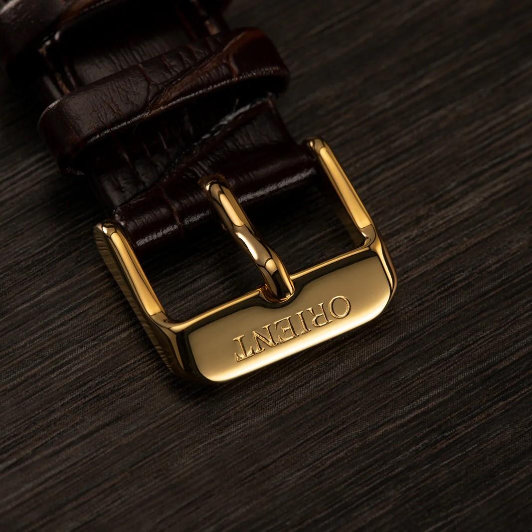 Brown leather watch strap with gold buckle labeled ORIENT