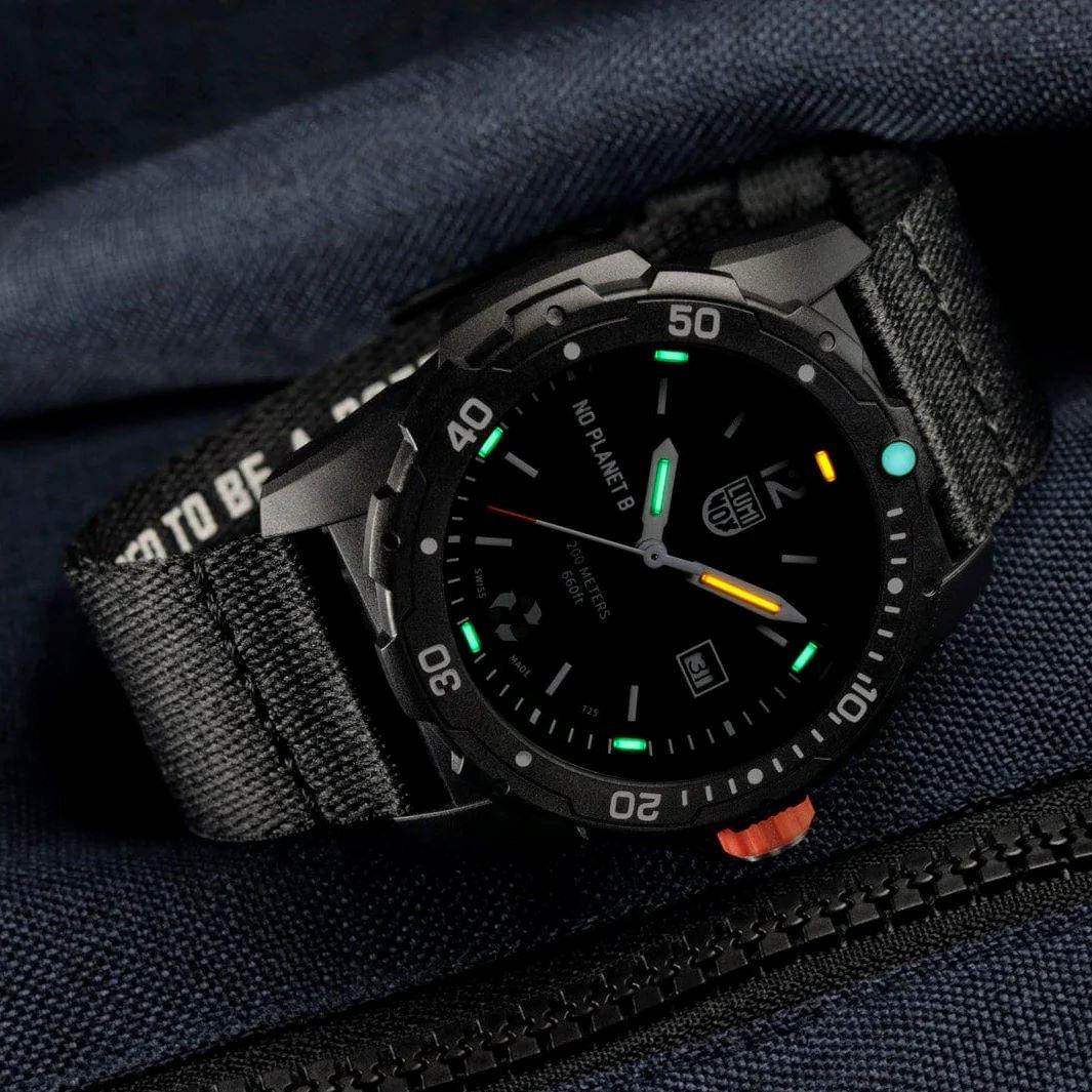 Close-up of black dial quartz watch with luminous hands and orange second hand