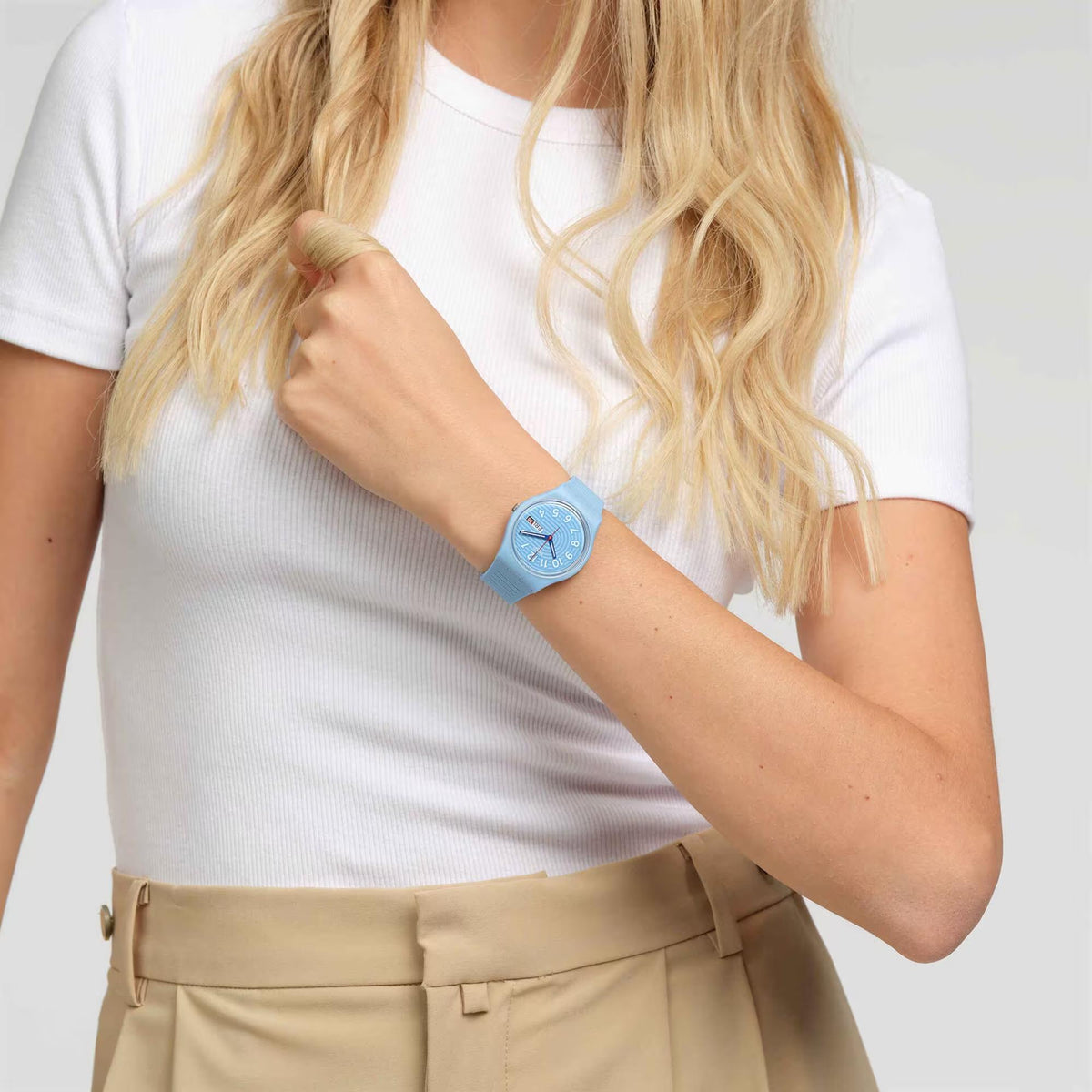 Light blue silicone strap watch on wrist, round light blue dial with date window