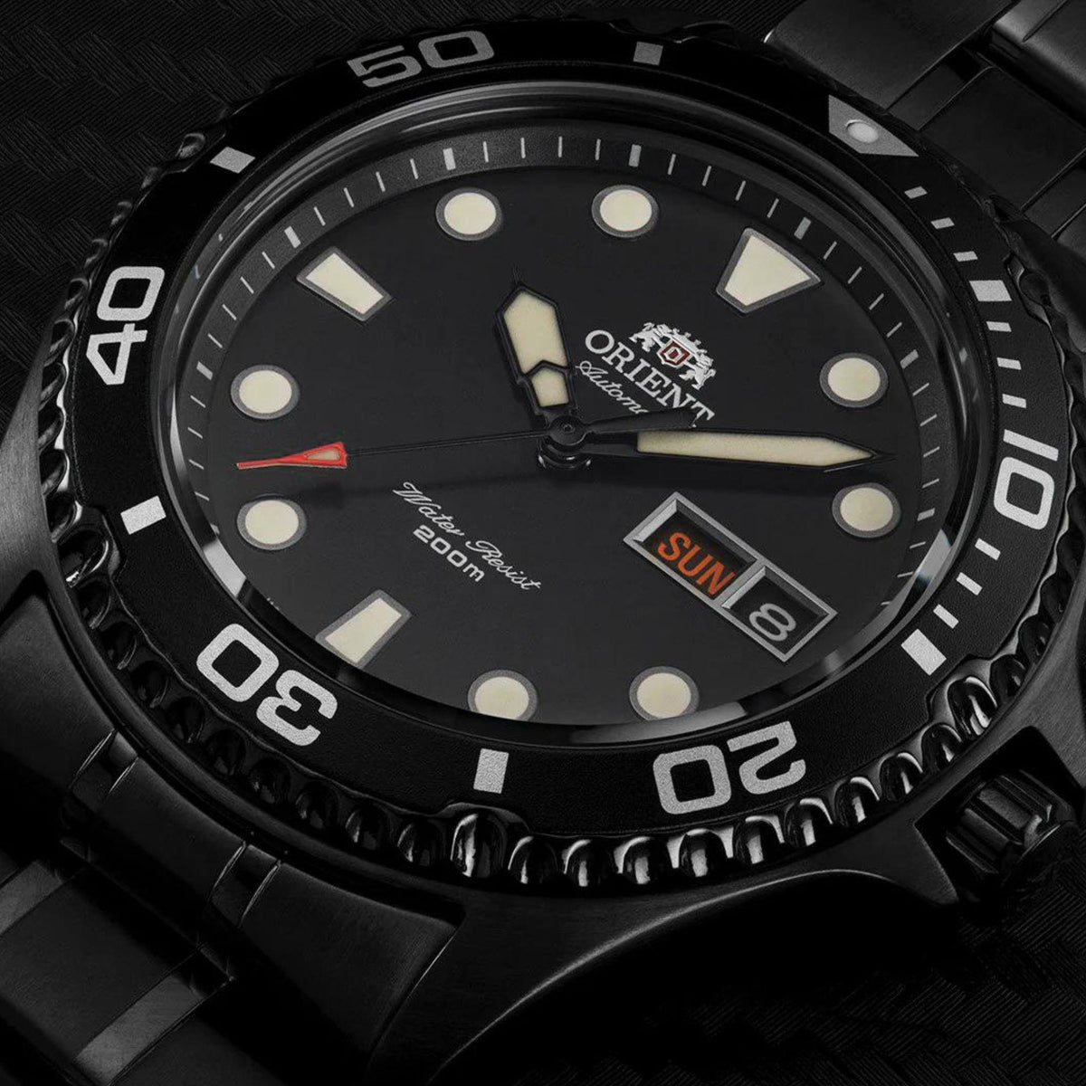Close-up of men's black dial steel automatic watch with markers, hands, and date window