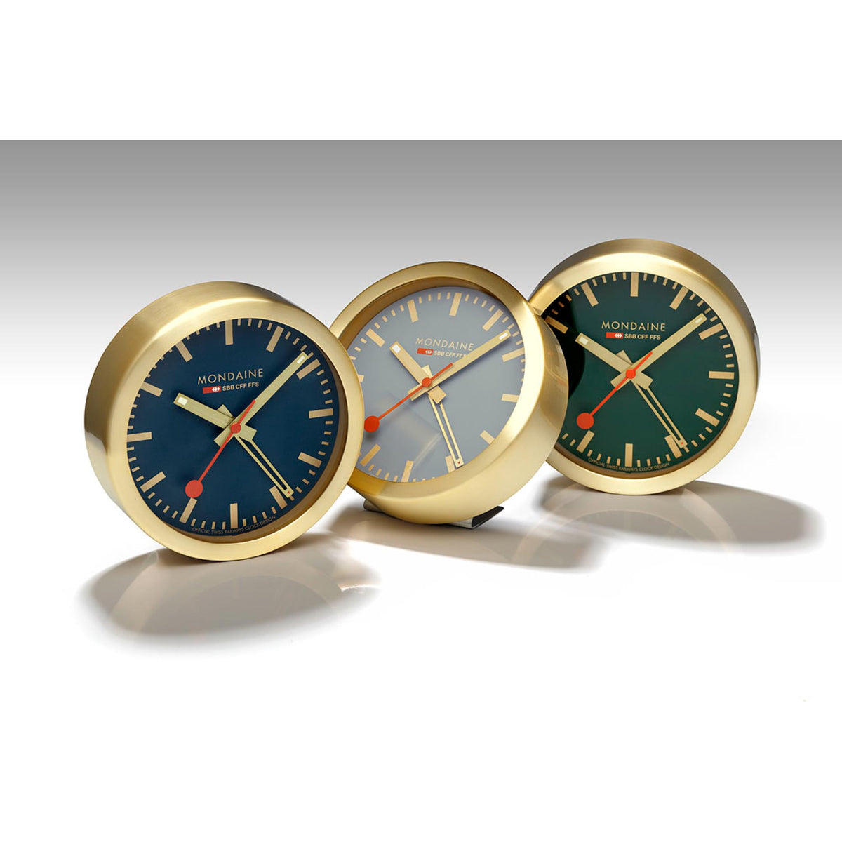 Three gold-tone table alarm clocks with blue-green faces and red second hands