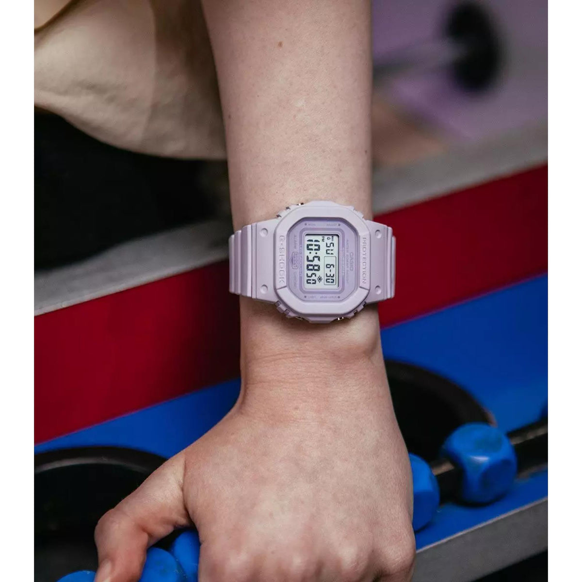 Lilac Casio G-Shock digital wristwatch on wrist with resin strap and square LCD