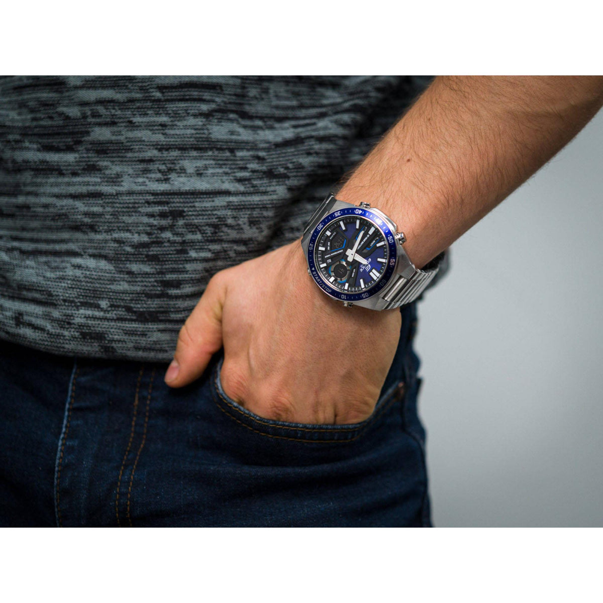 Men's stainless steel chronograph watch on wrist, blue dial, metal link bracelet