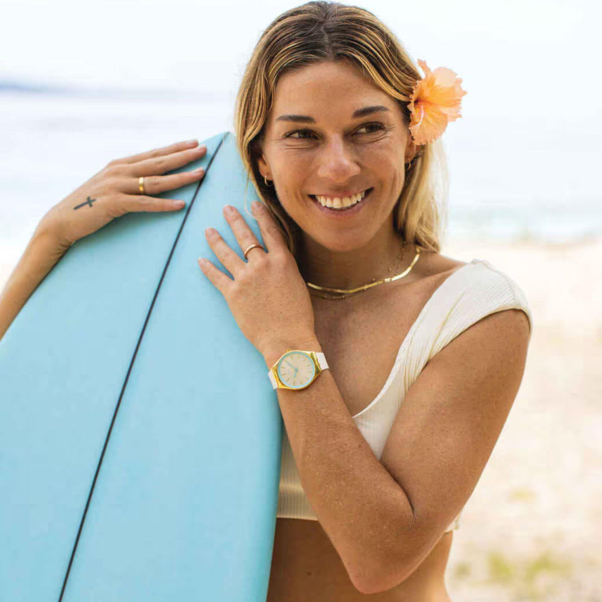 Ivory silicone watch on wrist with gold-tone case and blue-accent dial