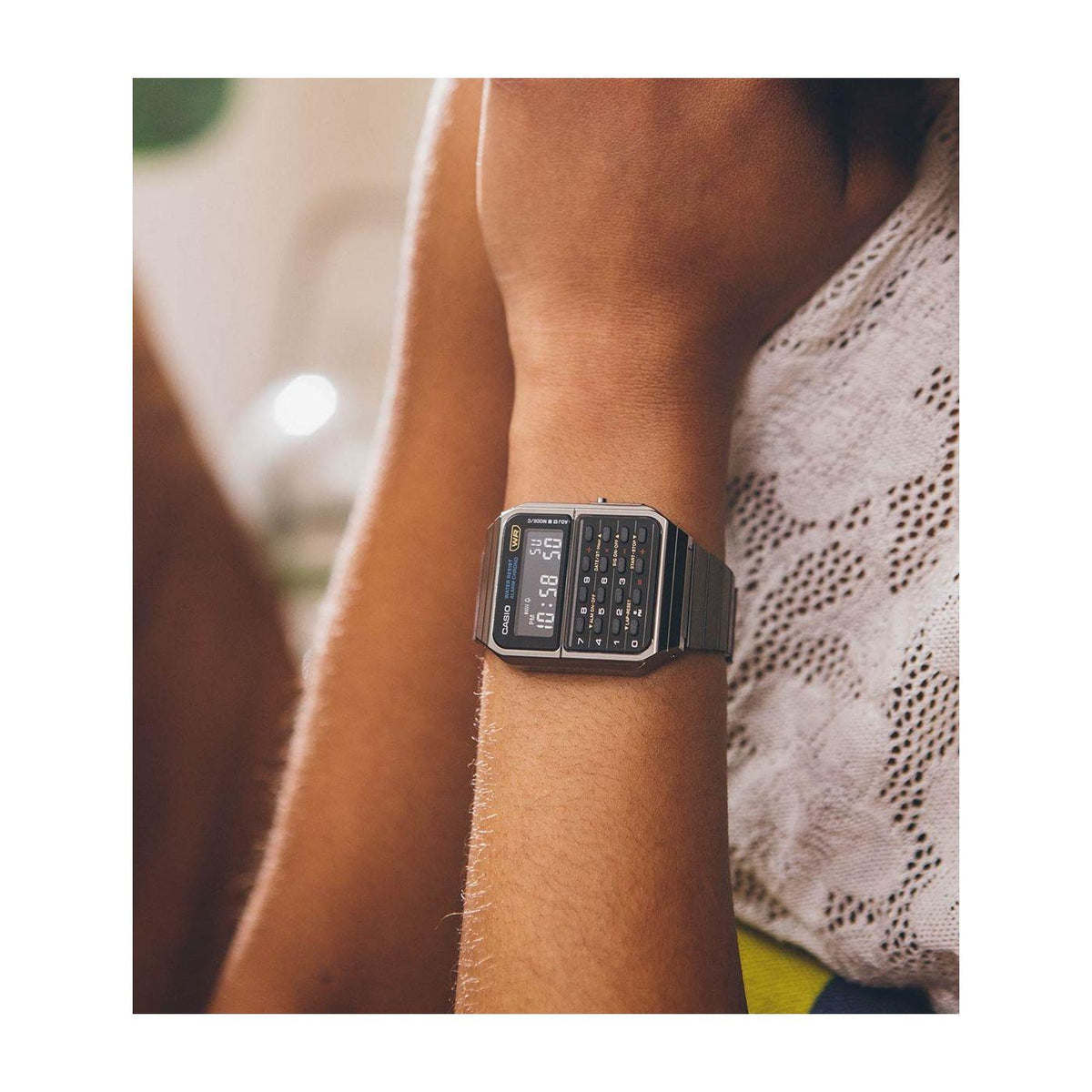 Casio digital calculator watch on wrist, black steel band, LCD time and button panel