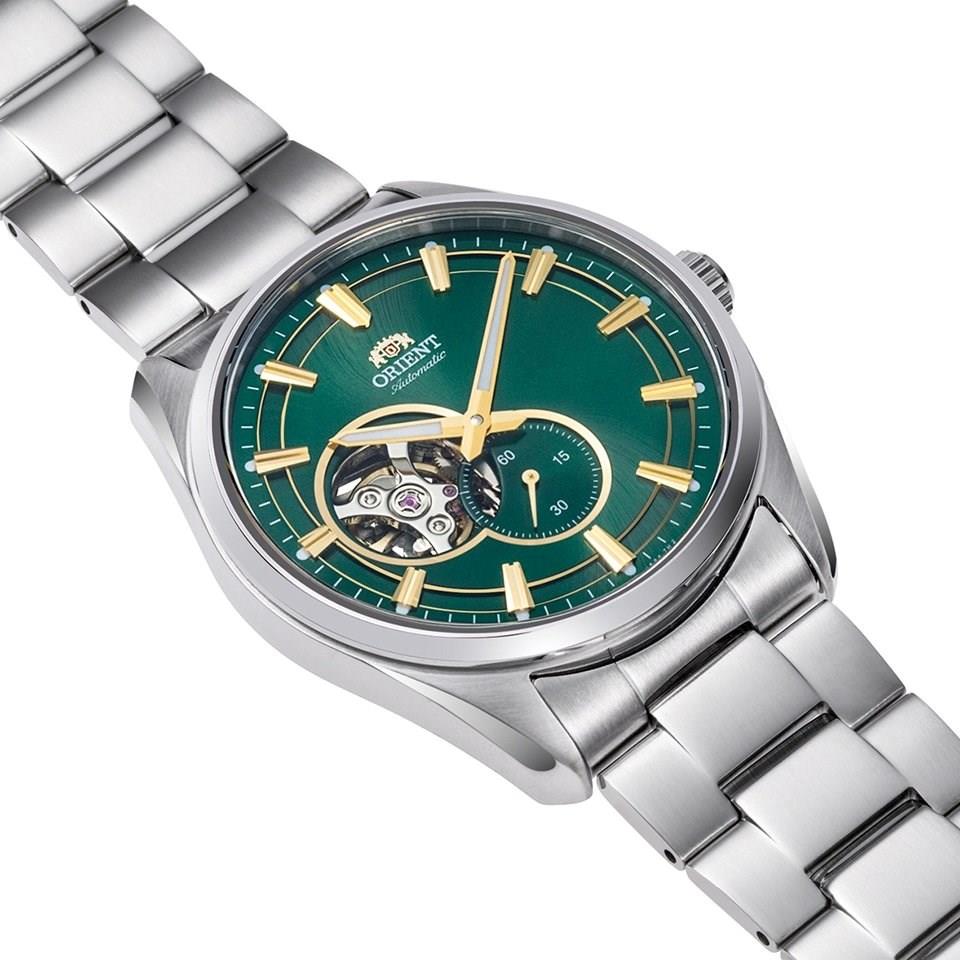 Stainless steel men’s watch with green dial, gold hands, and visible skeleton movement