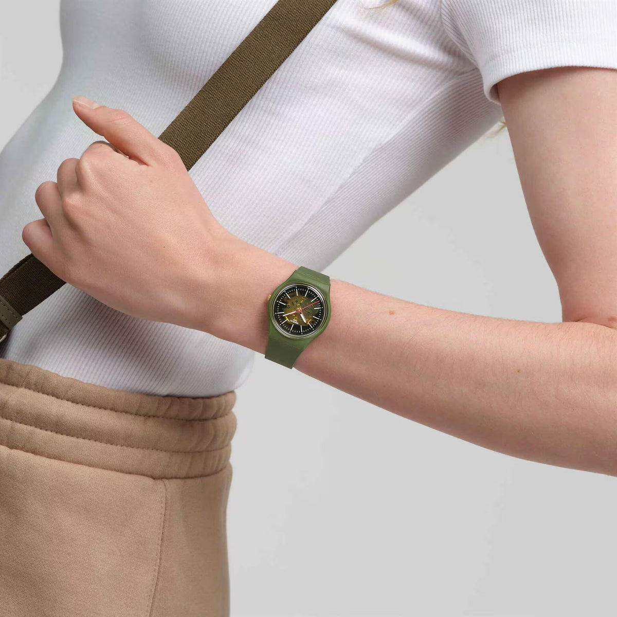 Men's quartz watch on wrist with green silicone strap, camo green dial and gold markers