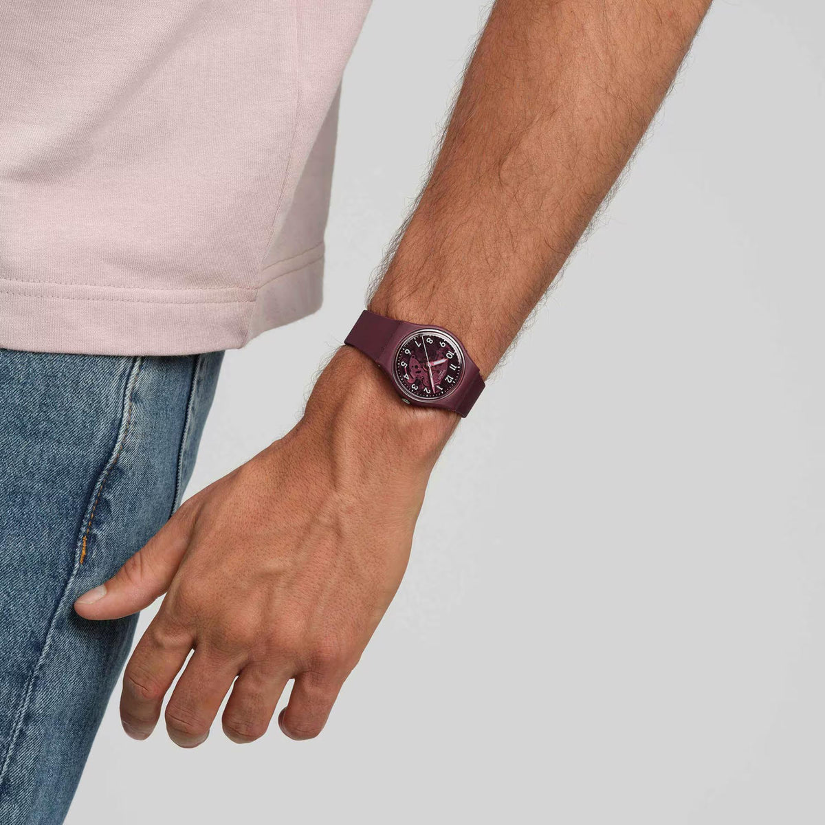 Men's quartz watch on wrist with red dial and dark maroon strap and buckle