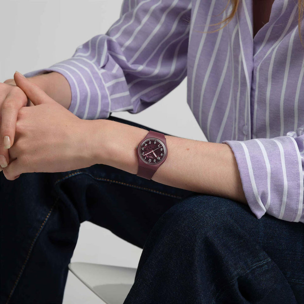 Men's quartz watch on wrist with red dial and dark maroon strap