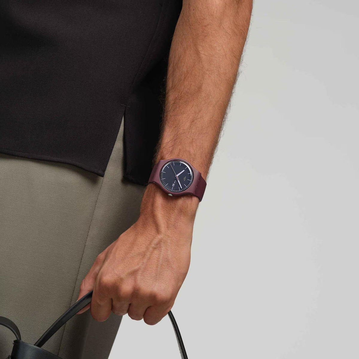 Men's watch worn on wrist: burgundy silicone band with dark navy dial and three hands.