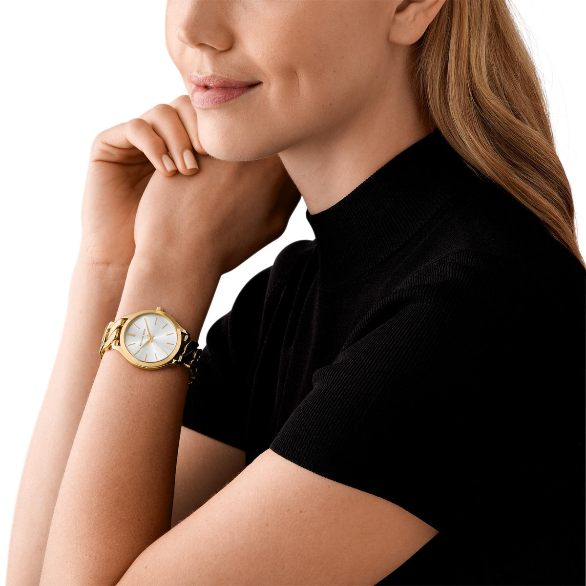 Women's gold-tone steel watch with white dial and link bracelet on wrist