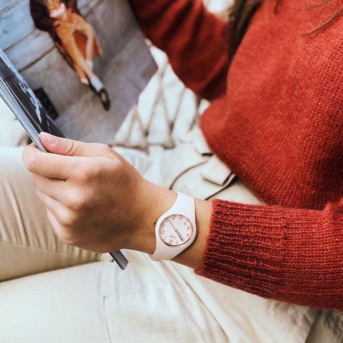 Pink dial silicone strap watch worn on wrist with long sleeve sweater.