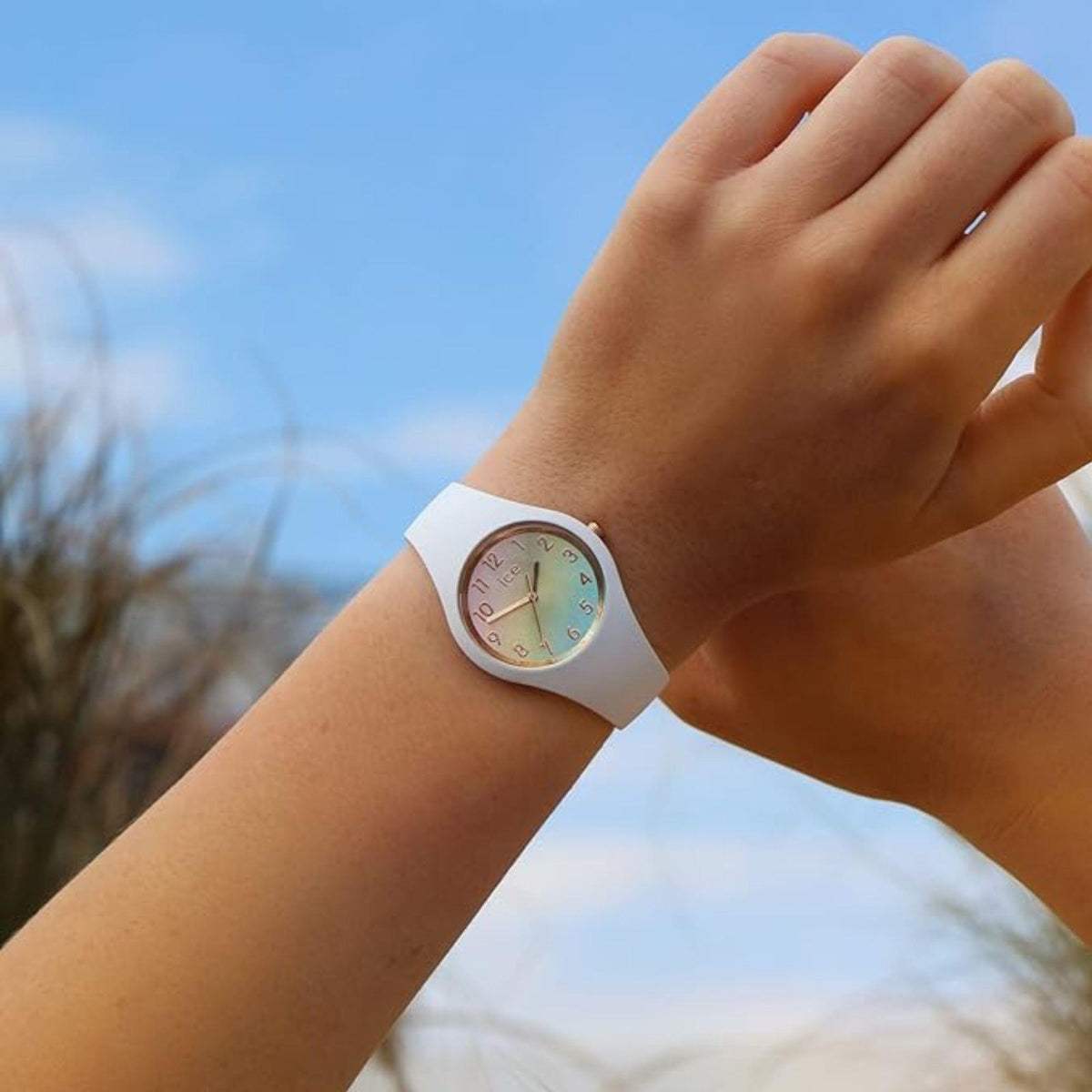 ICE Watch worn on wrist, rainbow dial with white silicone strap
