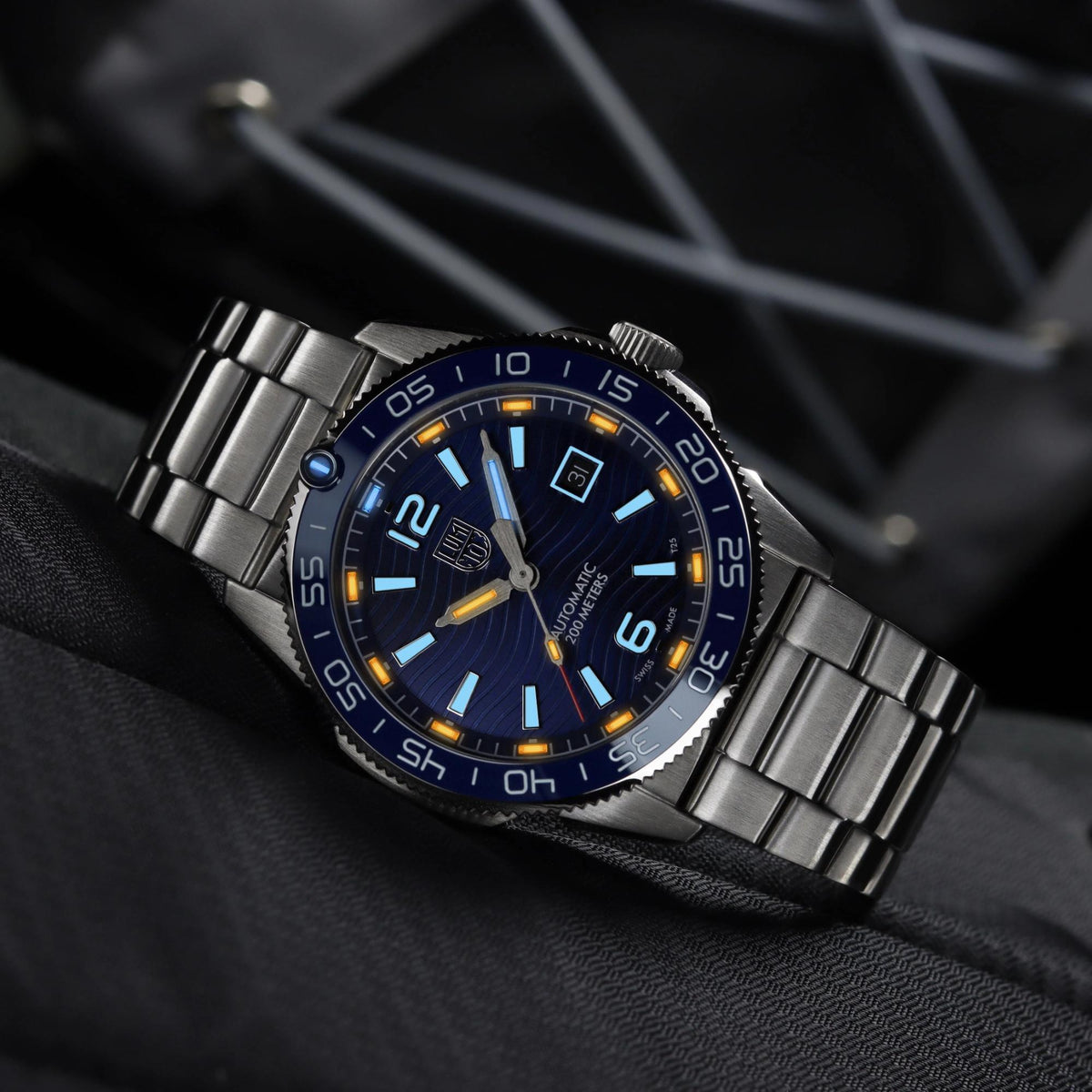 Stainless steel diver watch with blue dial, luminous numerals, and date window at 3