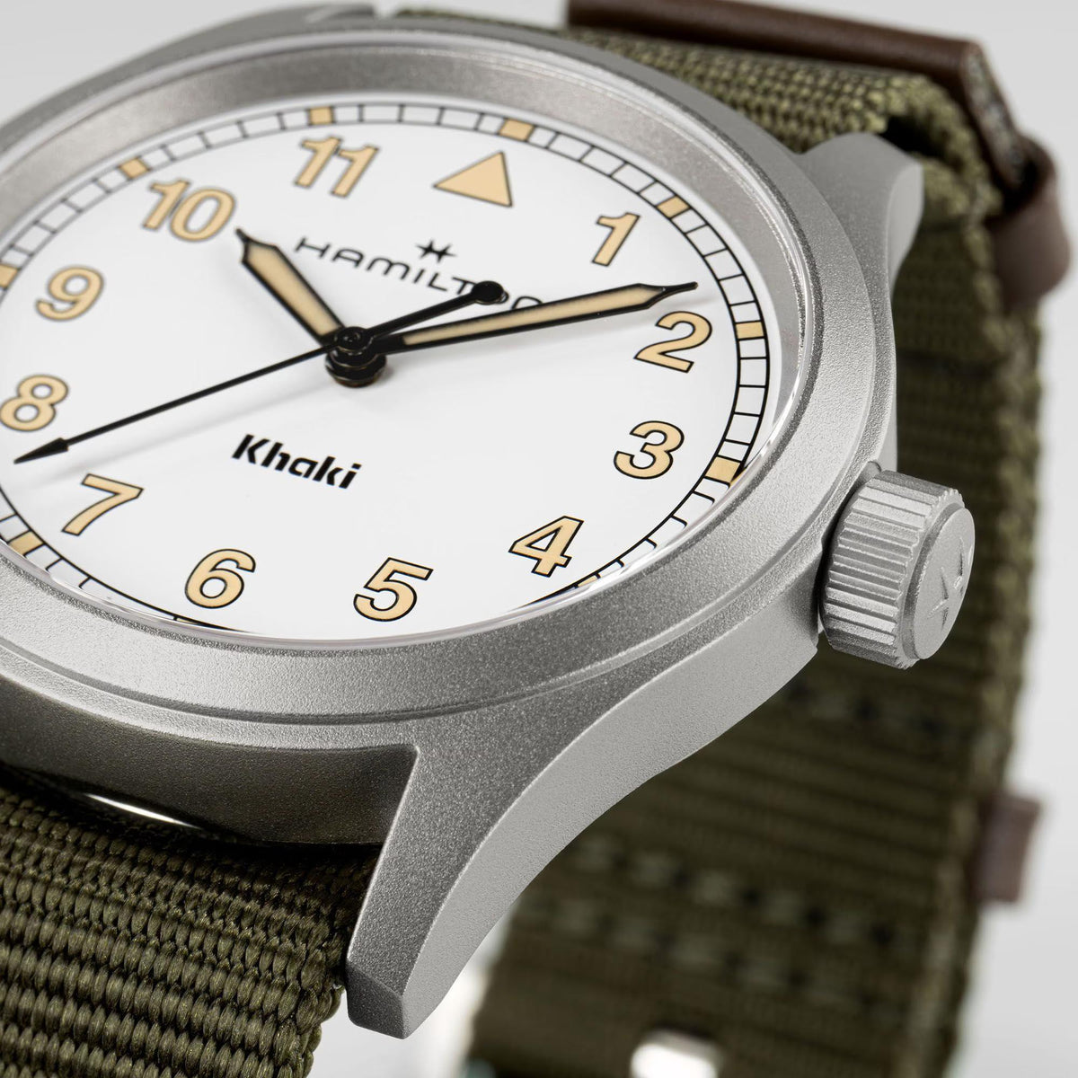 Hamilton Khaki Field H69401910 watch side profile displaying matte stainless steel case, engraved crown, and woven green strap