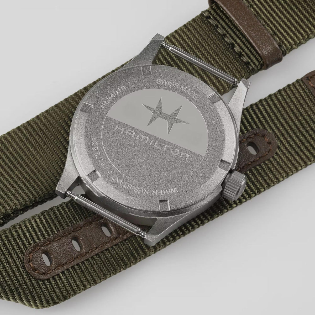 Hamilton Khaki Field H69401910 watch macro view showcasing matte steel bezel, crown detail, and white dial edge