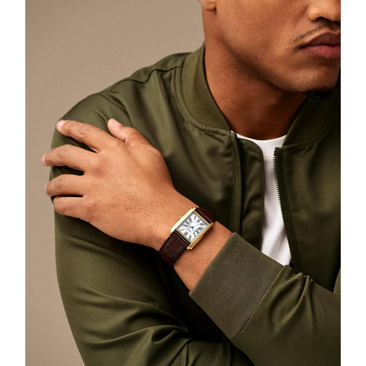 Fossil Carraway FS6011 30mm tank timepiece styled on a wrist, displaying a gold-tone rectangular case and brown leather band