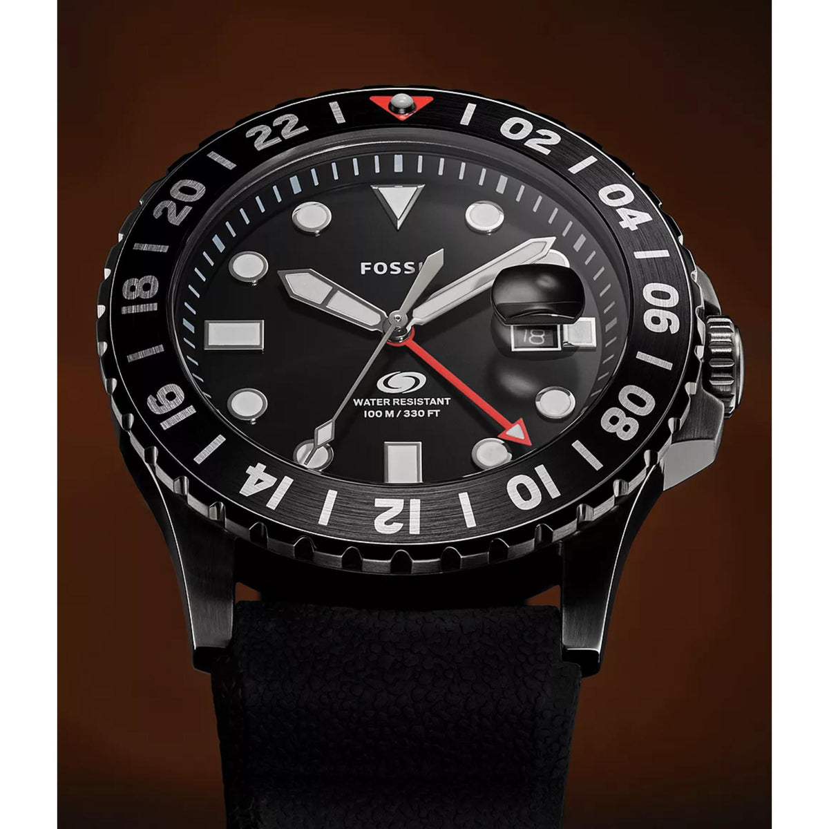 Close-up shot of the Fossil Blue GMT FS6036 watch highlighting the black dial texture, red arrow GMT hand, cyclops date lens, and luminous markers