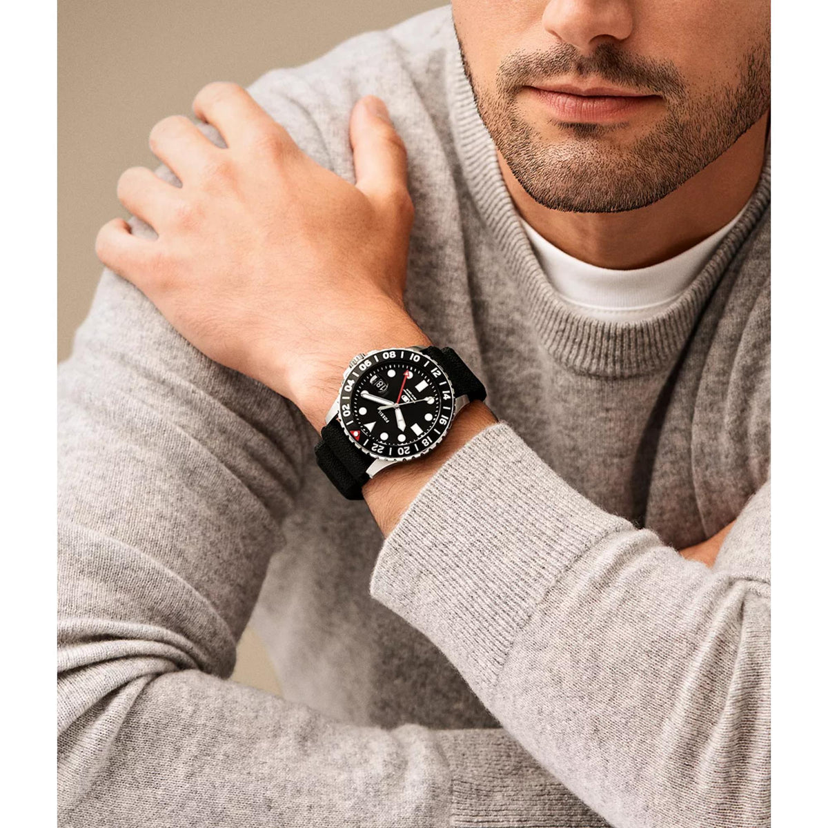 Model wearing the Fossil Blue GMT FS6036 46mm sports watch styled with a grey knitted jumper