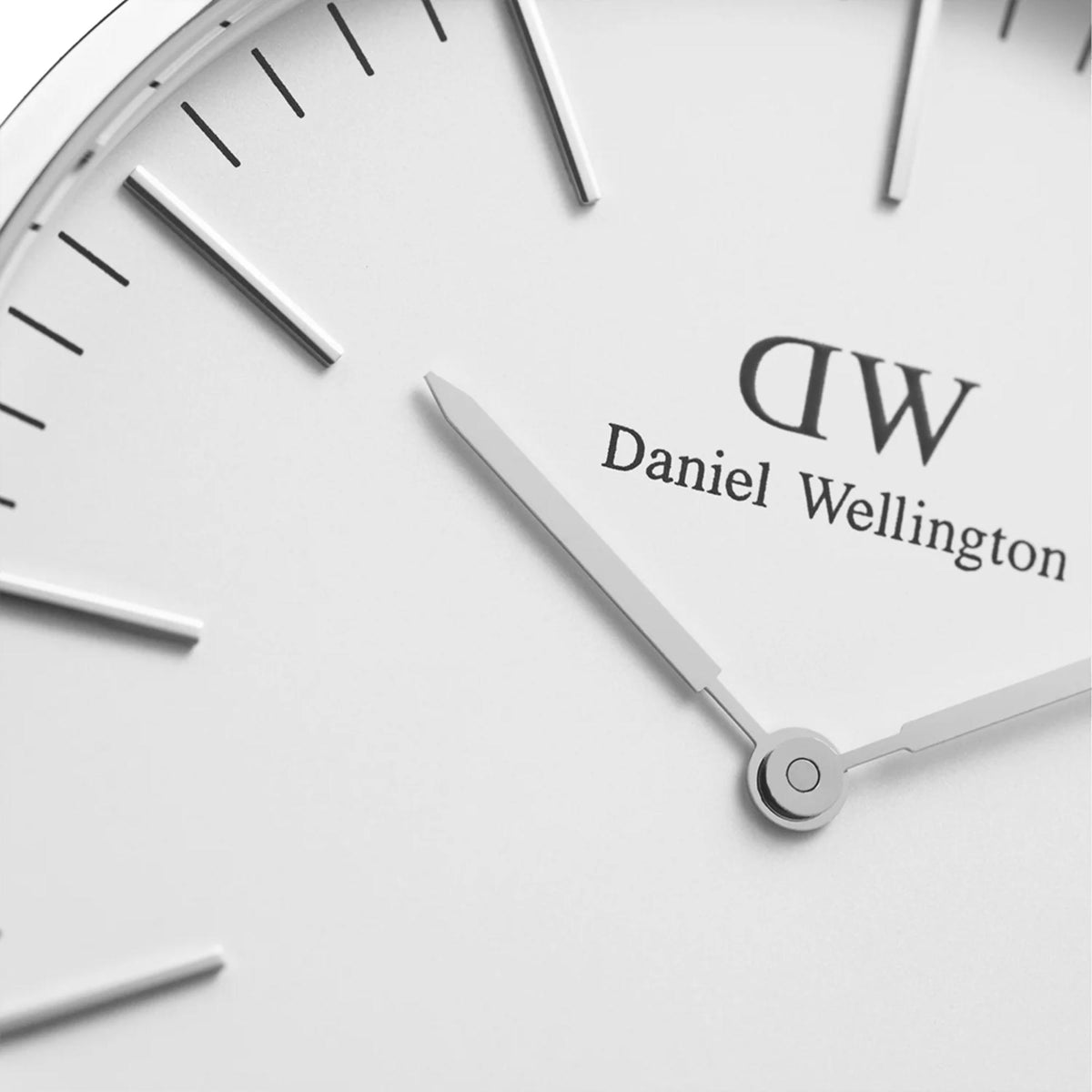 Close-up of the white dial, “DW” logo, and gold-tone hour and minute hands