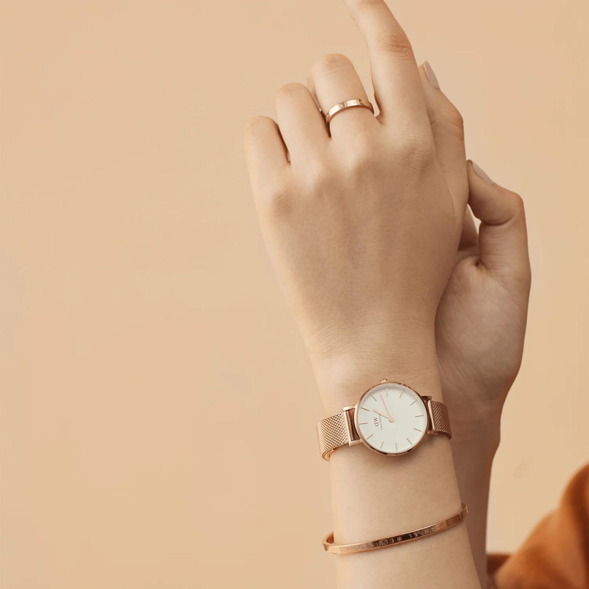 Rose-gold quartz watch with white dial on wrist, close-up