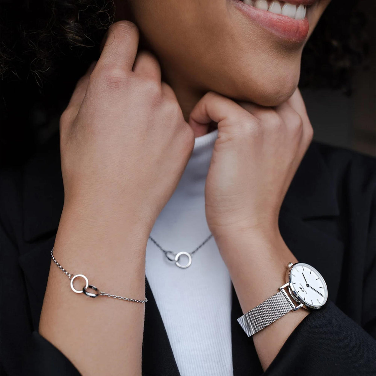 Ladies quartz watch on wrist with white dial and stainless steel mesh strap.