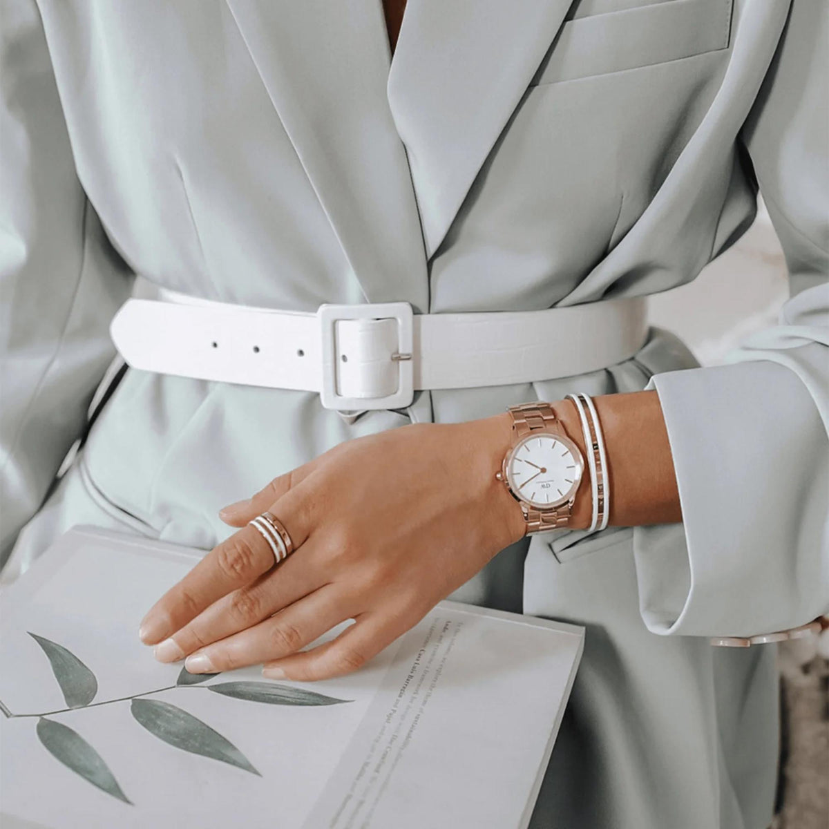 Daniel Wellington quartz watch on wrist with rose-gold steel bracelet and white dial