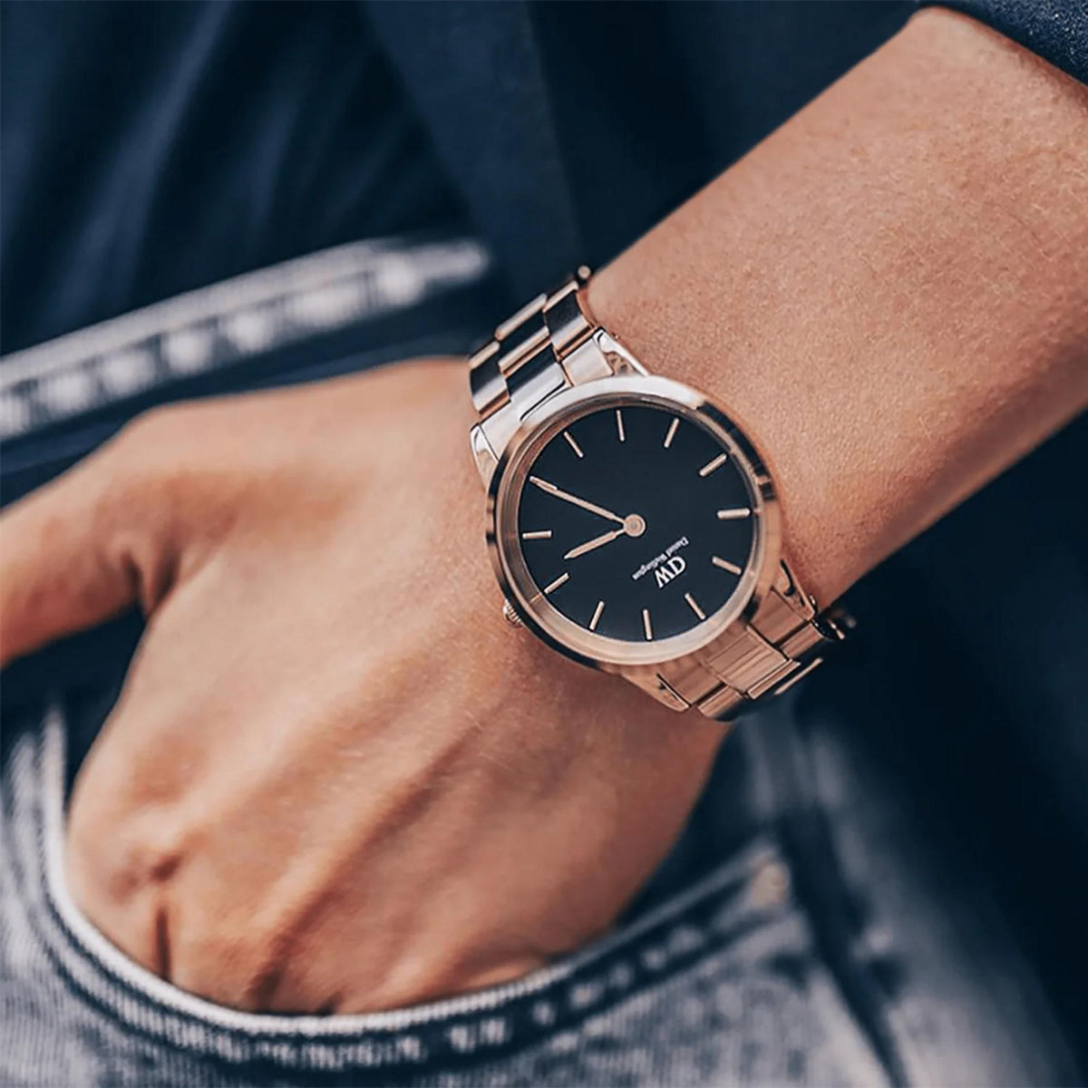 Mens wristwatch with dark dial and metal link bracelet, worn on wrist