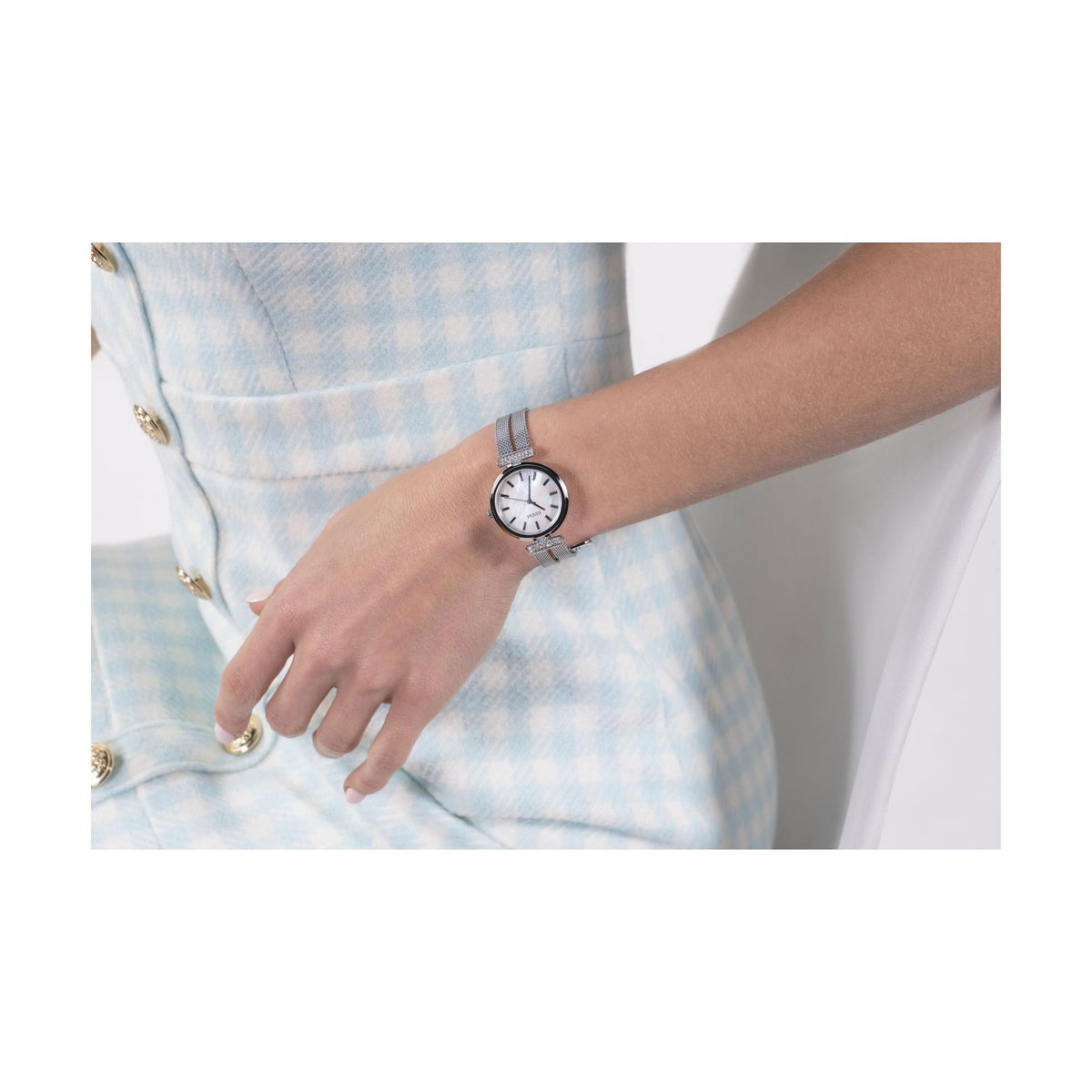 Ladies stainless steel mesh strap watch worn on wrist with mother-of-pearl dial