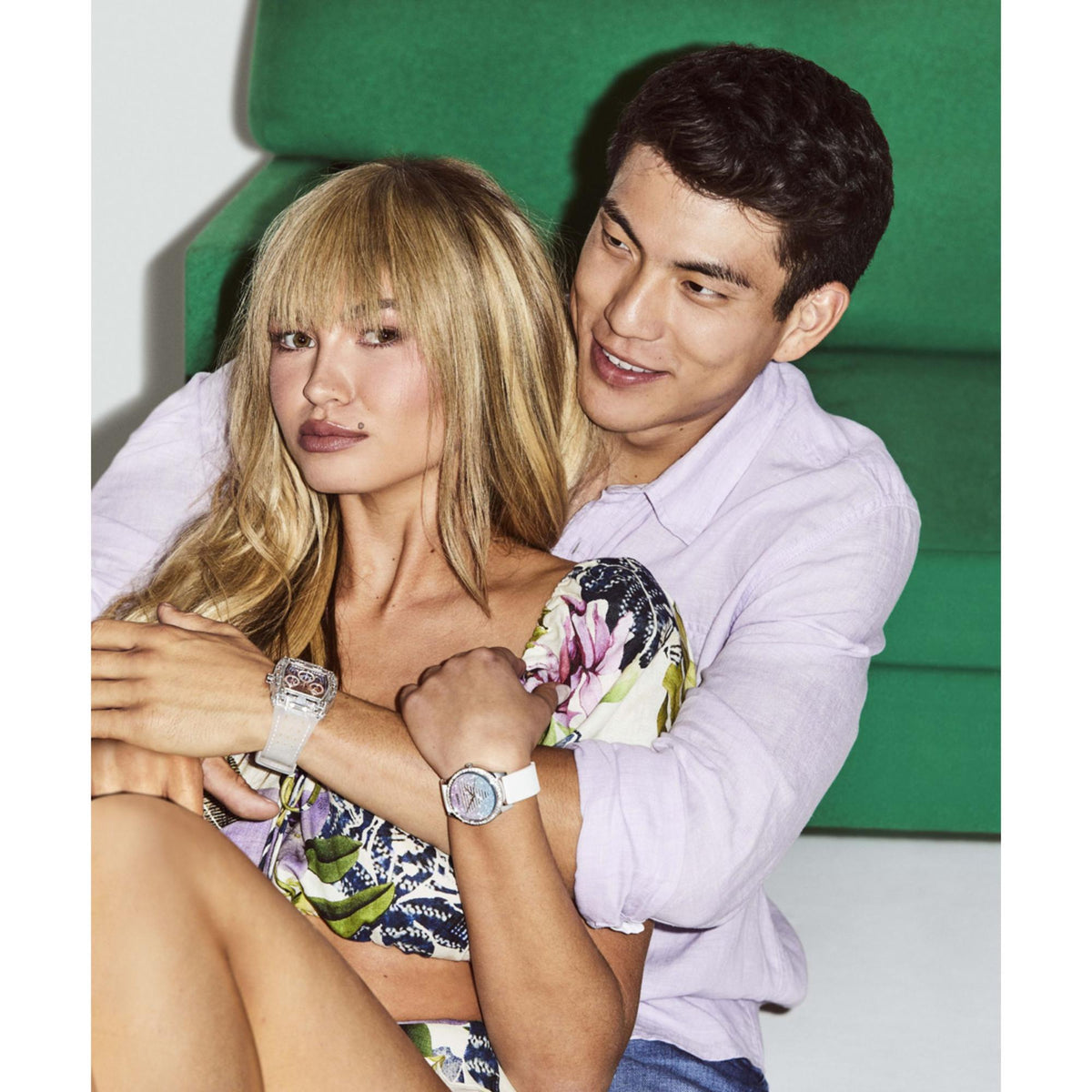 Man’s and woman’s clear watches on couch, visible rectangular faces and transparent straps