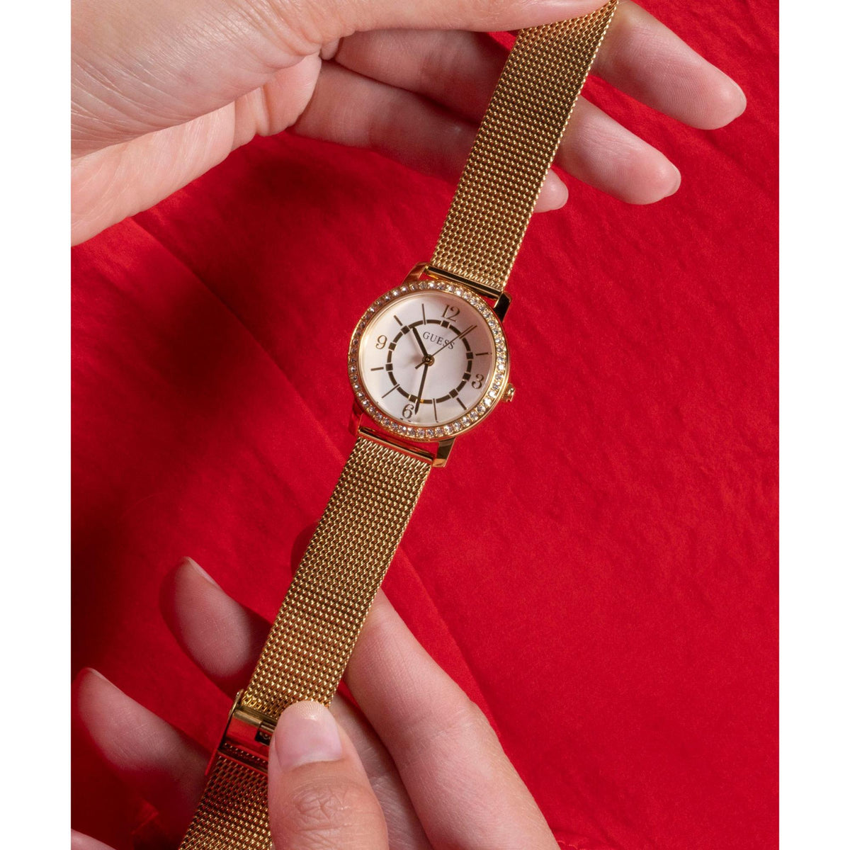 Womens analog watch on wrist, gold mesh strap and crystal bezel, white dial