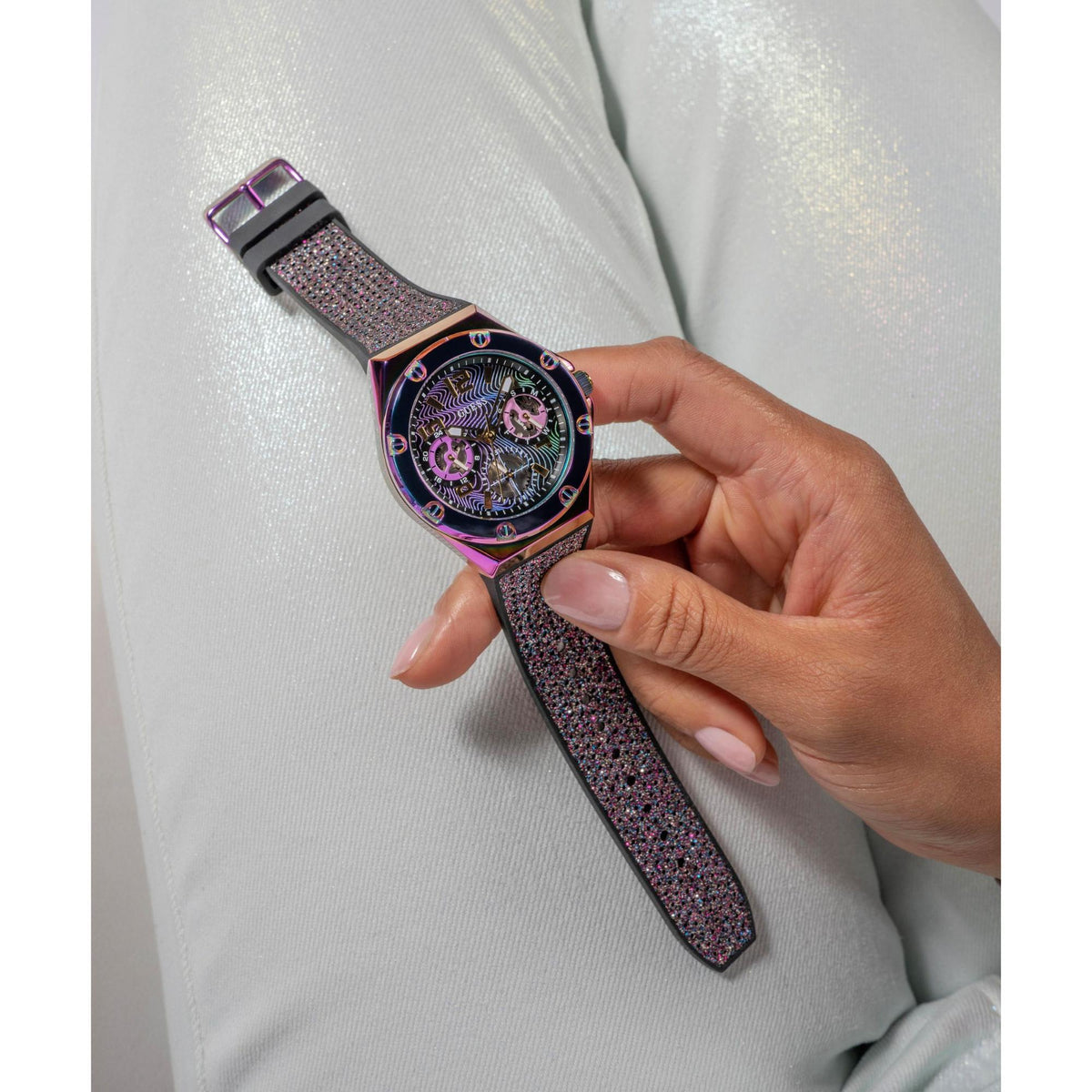 Iridescent multi-function watch on hand with black glitter strap