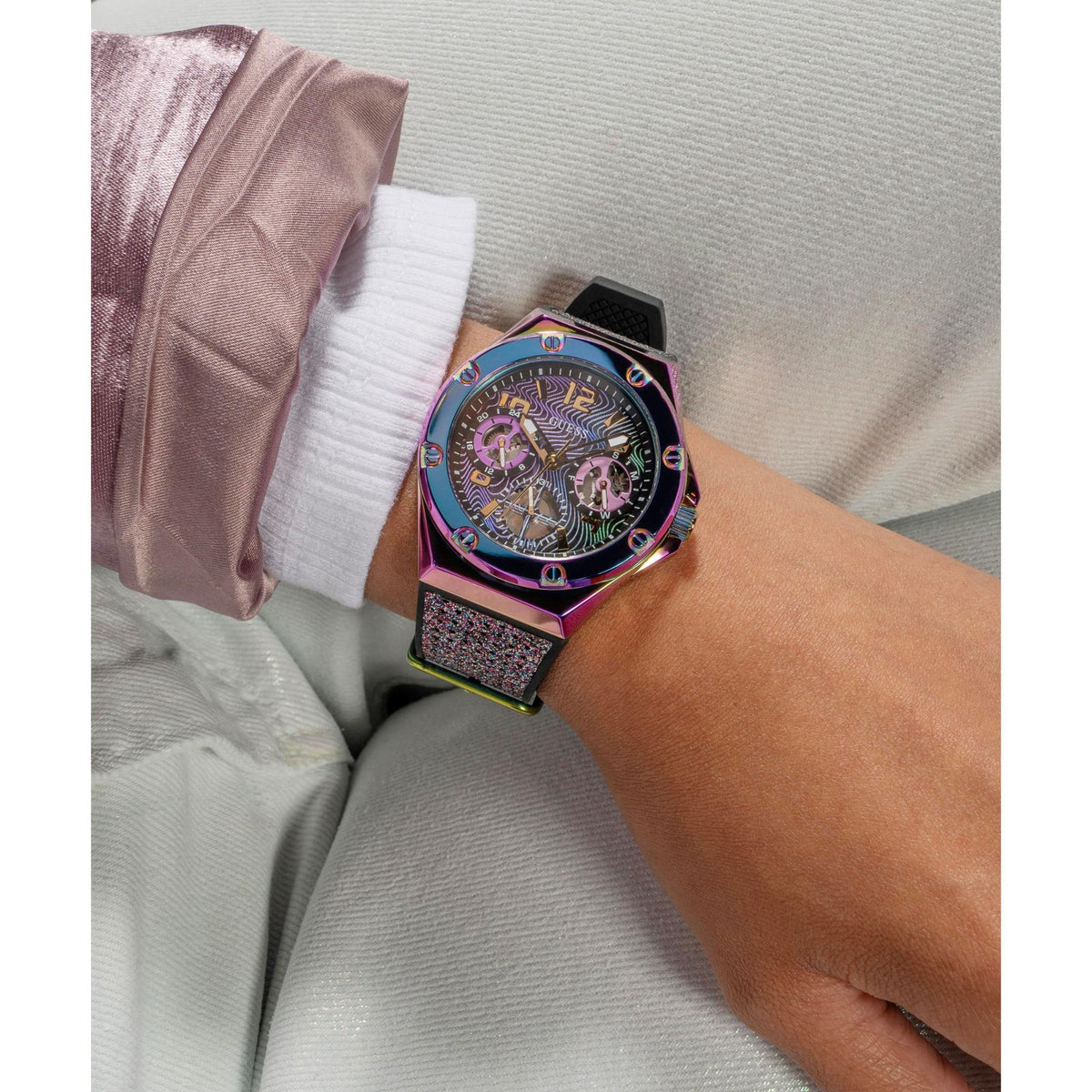 Iridescent multi-function watch worn on wrist with black glitter strap