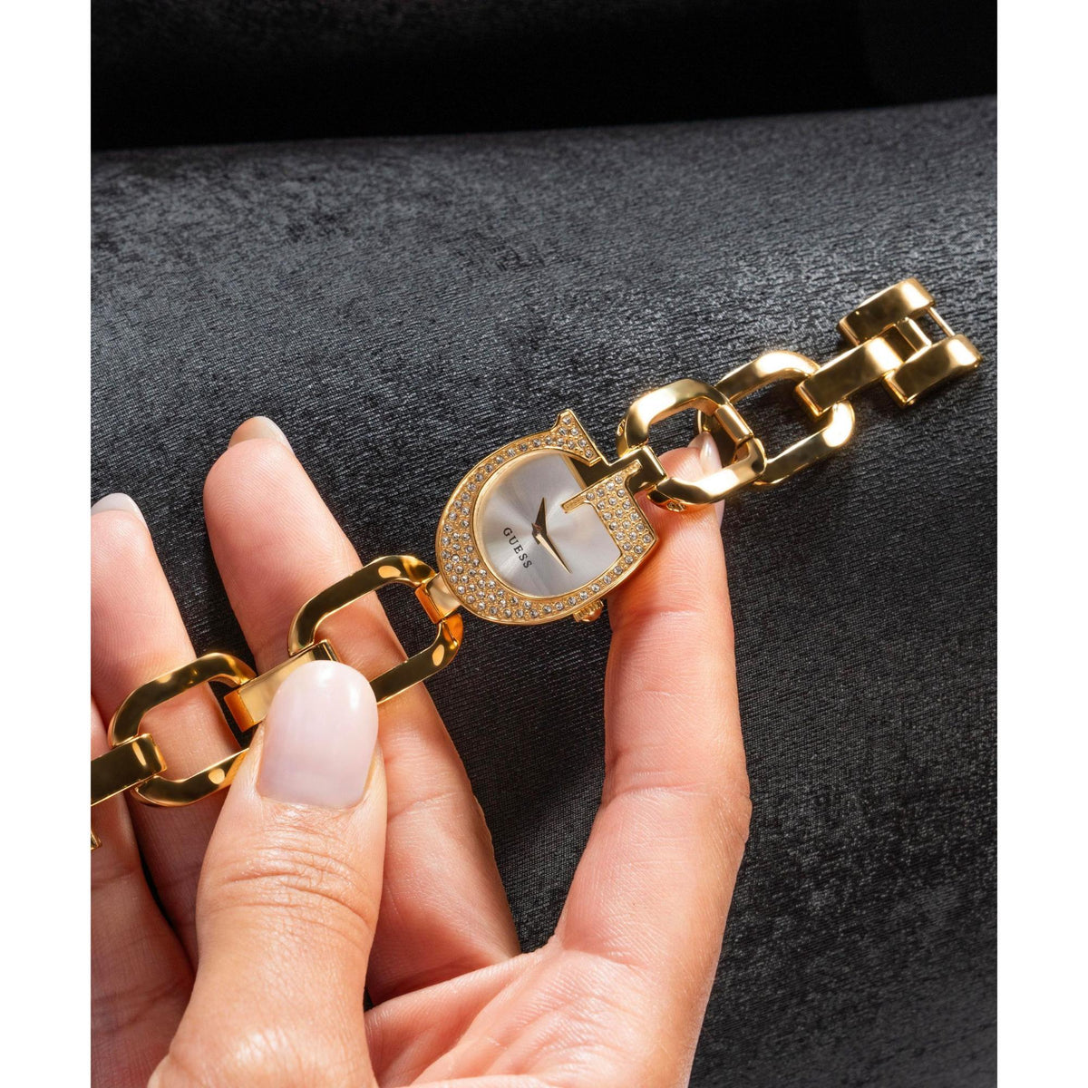 Gold tone analog watch on wrist with silver dial and crystal bezel, link bracelet