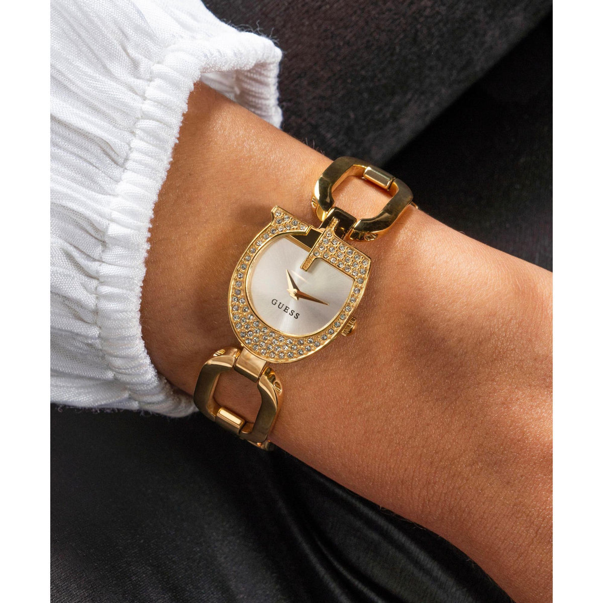 Gold tone analog ladies watch on wrist with crystal bezel and silver dial, link bracelet