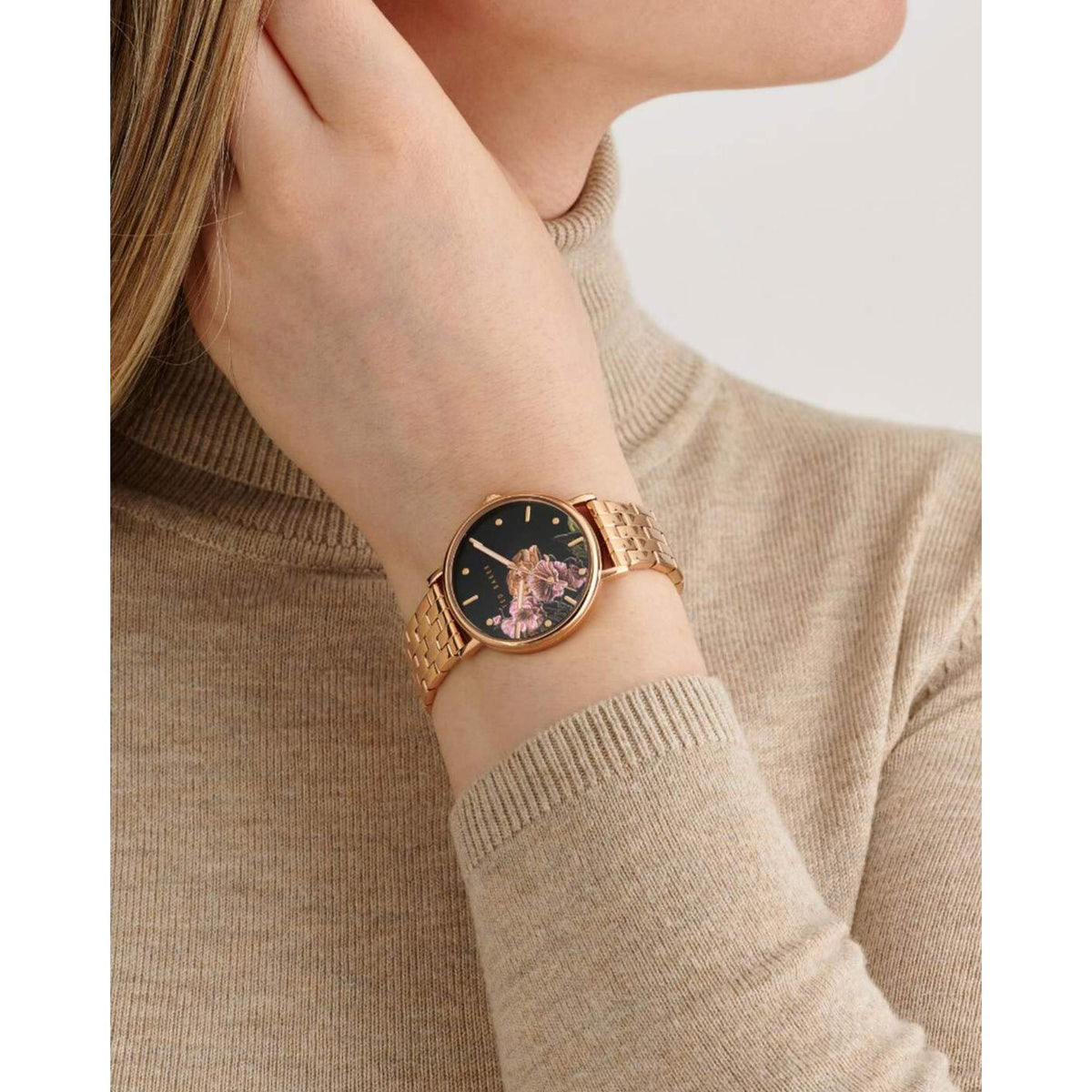 Rose gold-tone ladies watch on wrist with black floral dial and metal mesh bracelet
