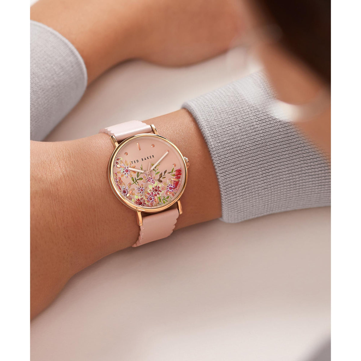 Ted Baker ladies wristwatch on wrist with pink leather strap, floral dial and gold-tone bezel