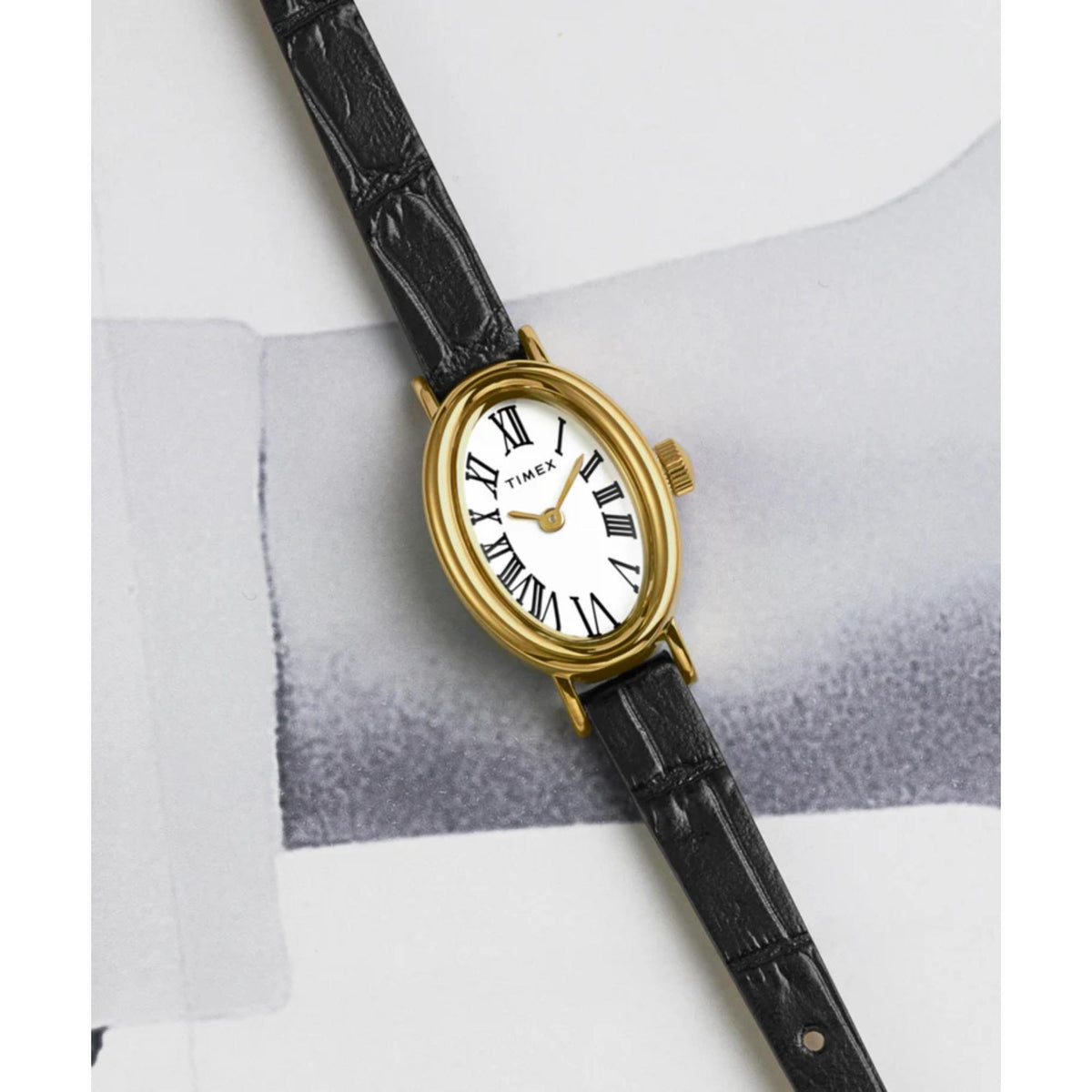 Black leather ladies watch showing white dial with Roman numerals and gold-tone hands