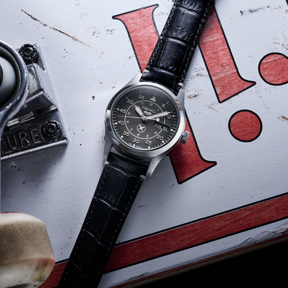 Seiko 5 Sports SRPL31K1 flat lay view on white skateboard graphic background