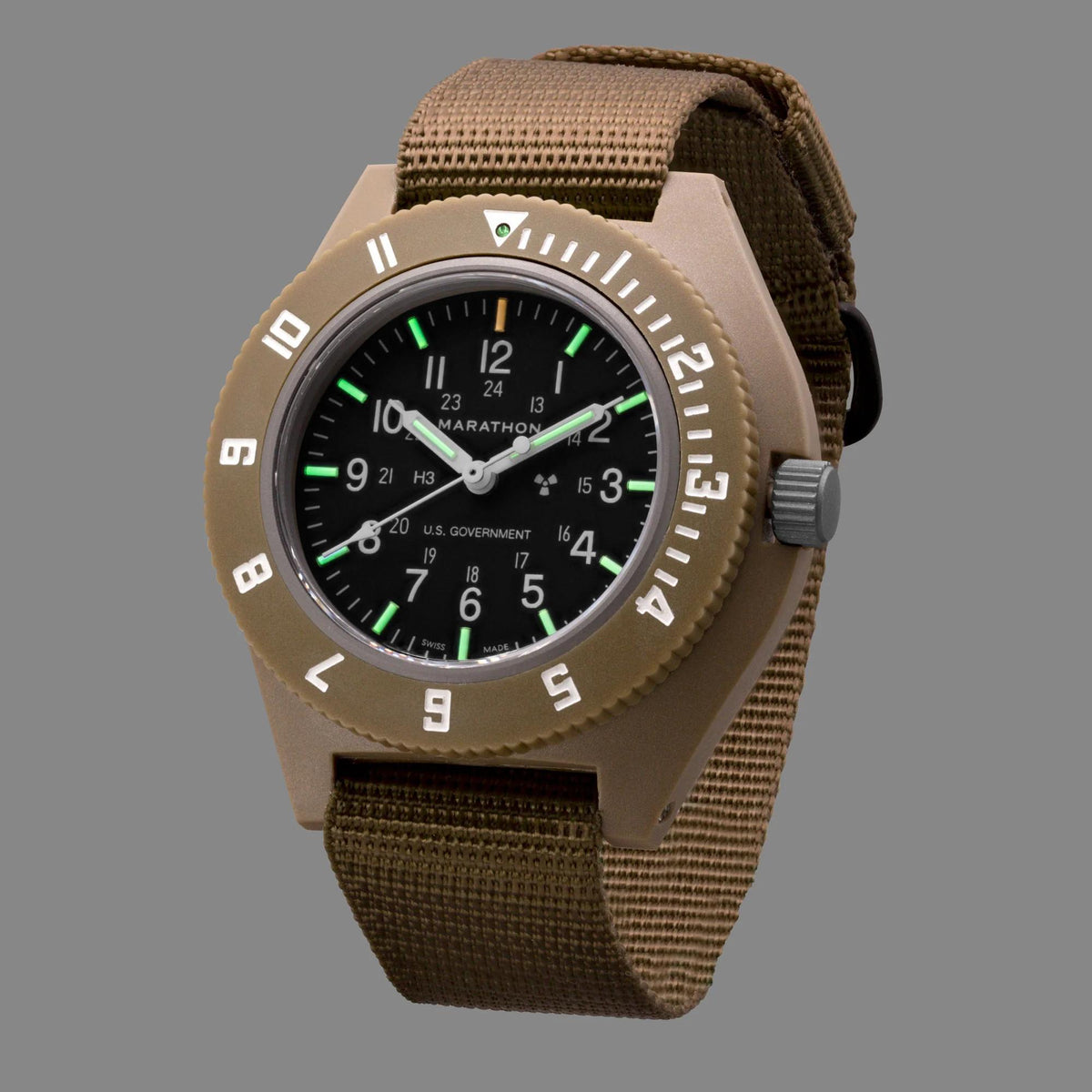 Men's desert tan watch with black dial, green accent hands, and brown fabric strap