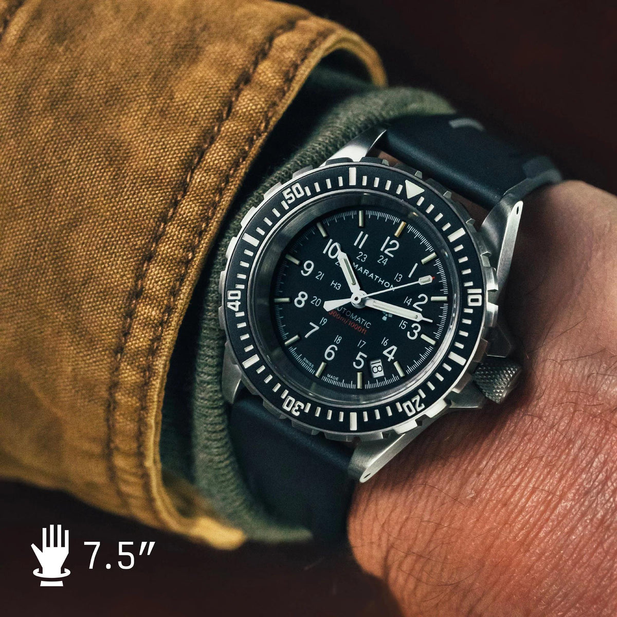 Men's diver watch on wrist with black dial, black rubber strap, and bezel detail