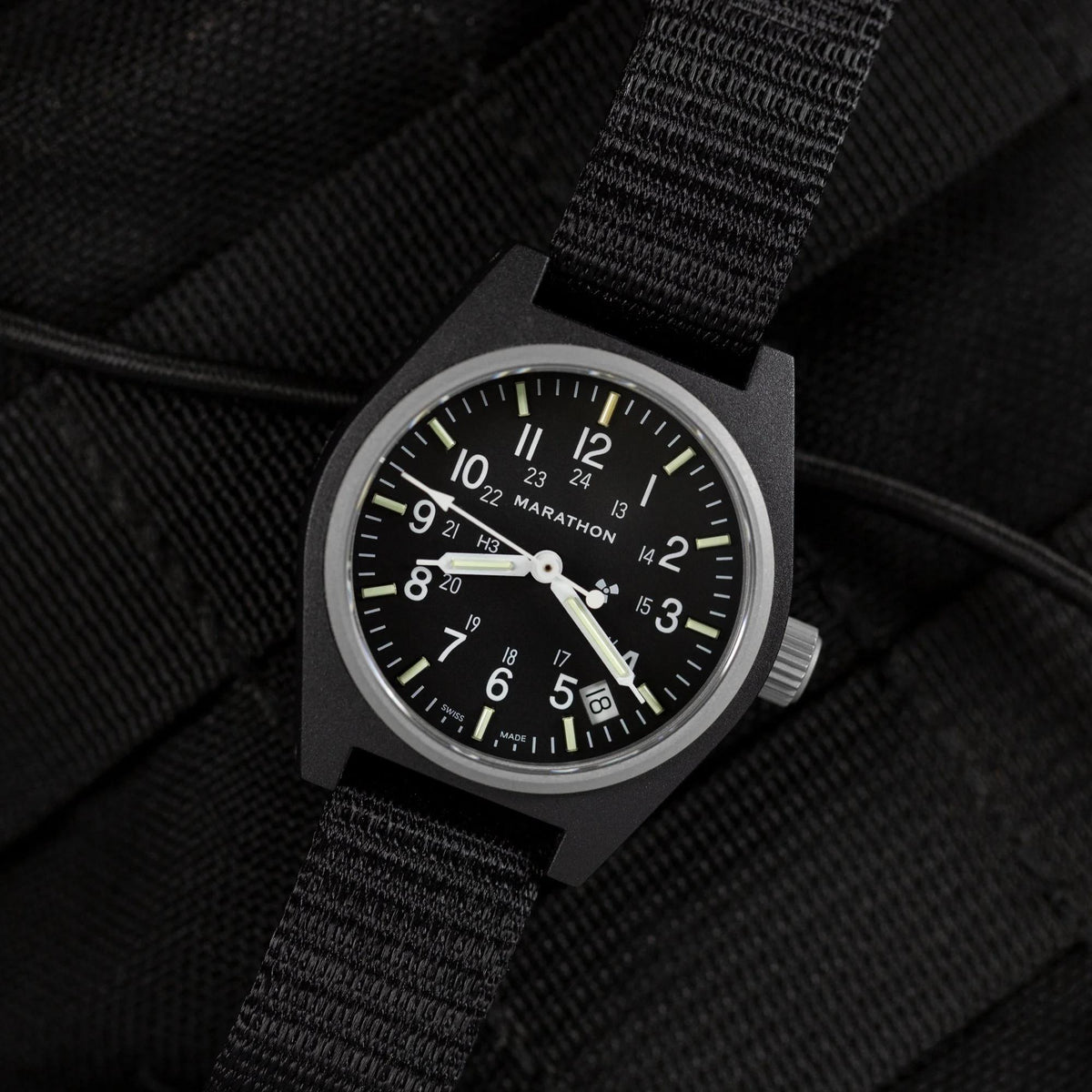 Close-up of black dial Marathon quartz men's watch with date window and lumed markers