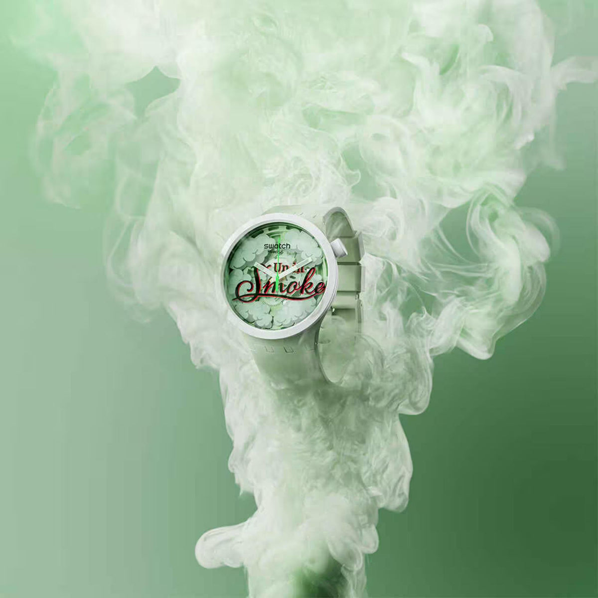 Mint green Swatch watch with round dial surrounded by light green smoke clouds