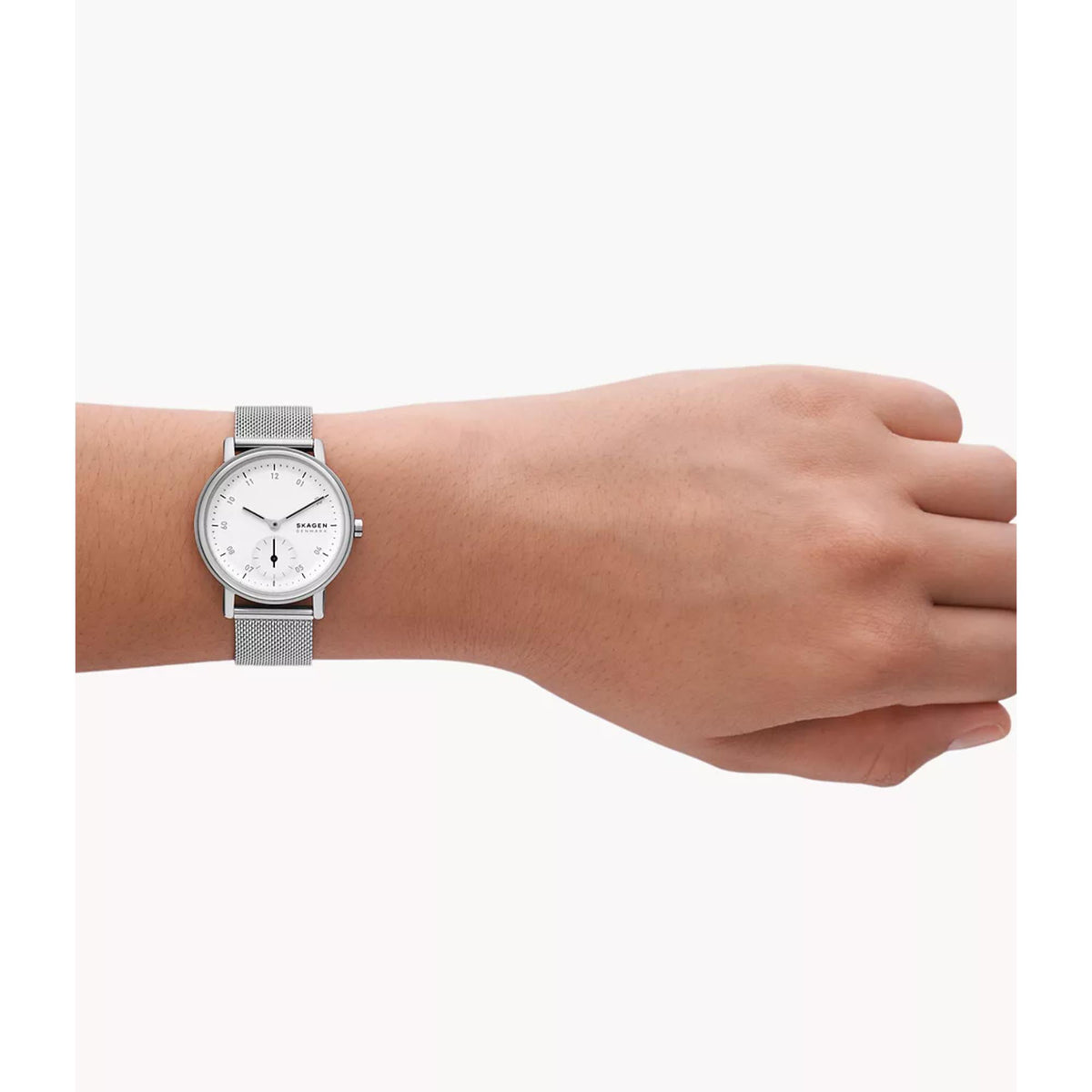 Women’s watch on wrist with white dial and silver mesh strap