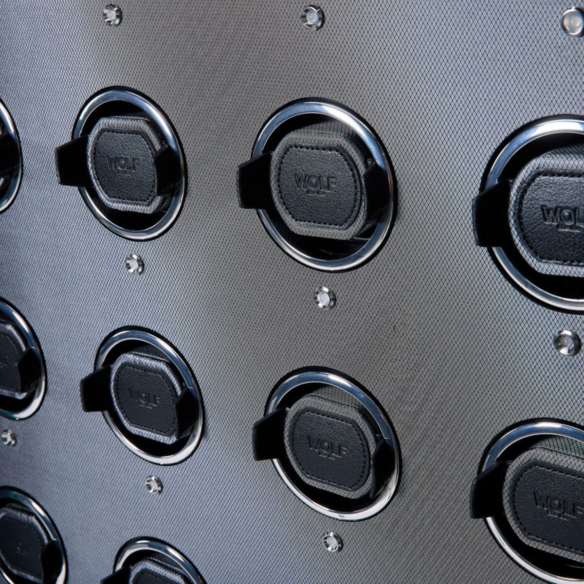 Close-up of WOLF watch winding bases with circular metal rings and screw heads