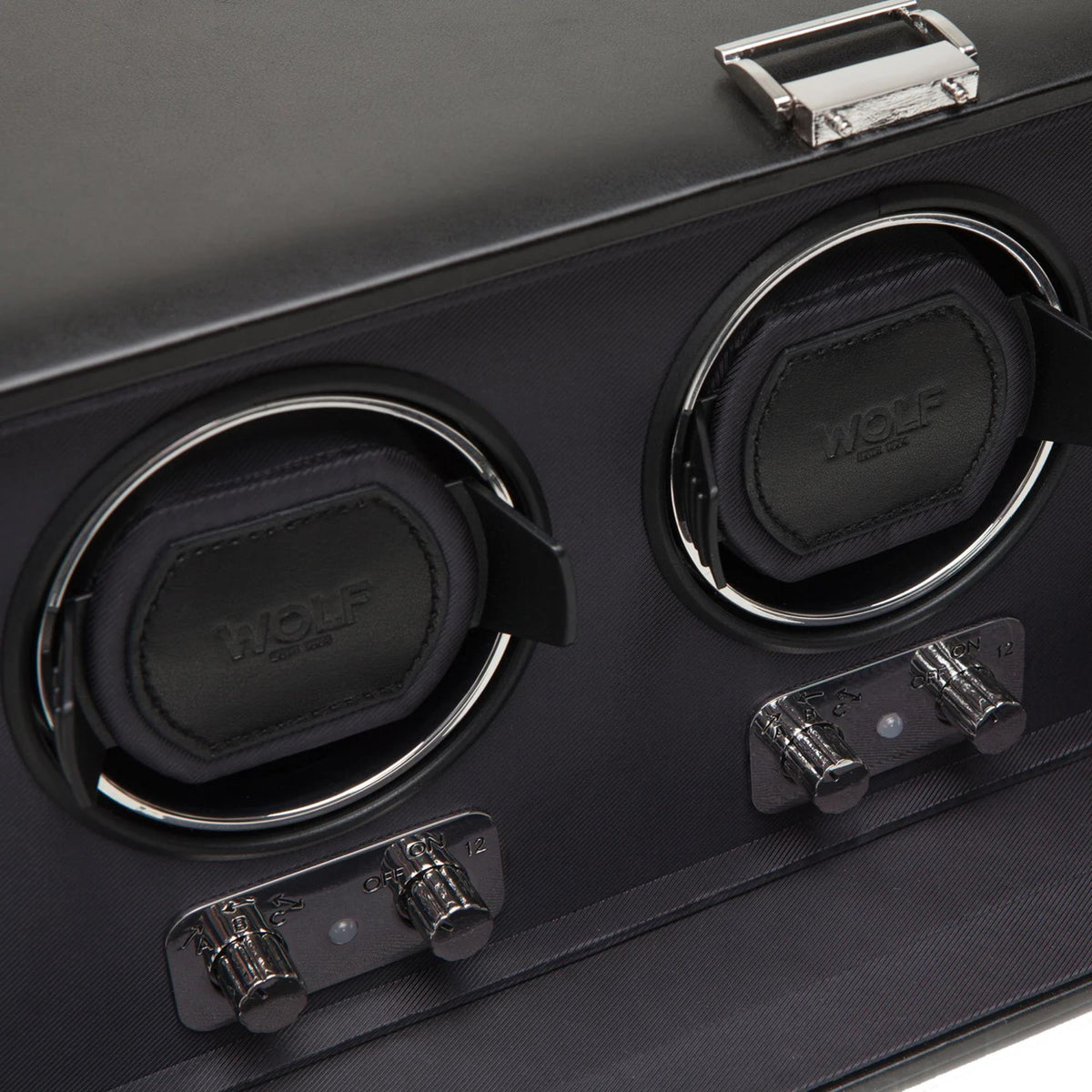 Triple watch winder close-up: leather-look watch holders and chrome switch bar