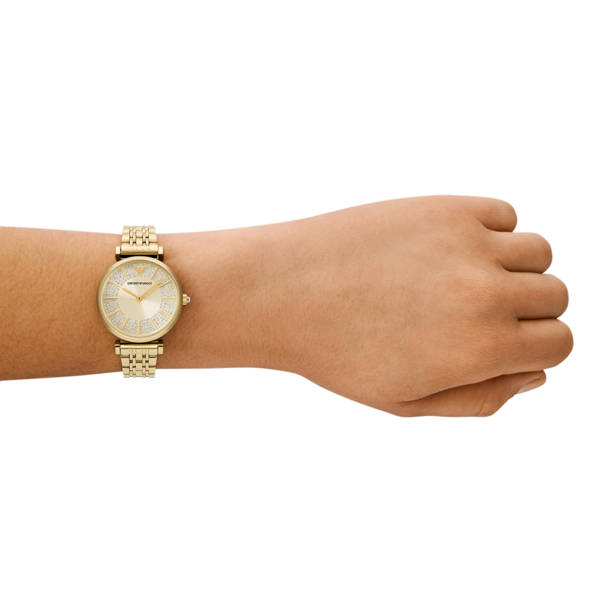 Emporio Armani ladies quartz watch worn on wrist, gold-tone bracelet and cream dial